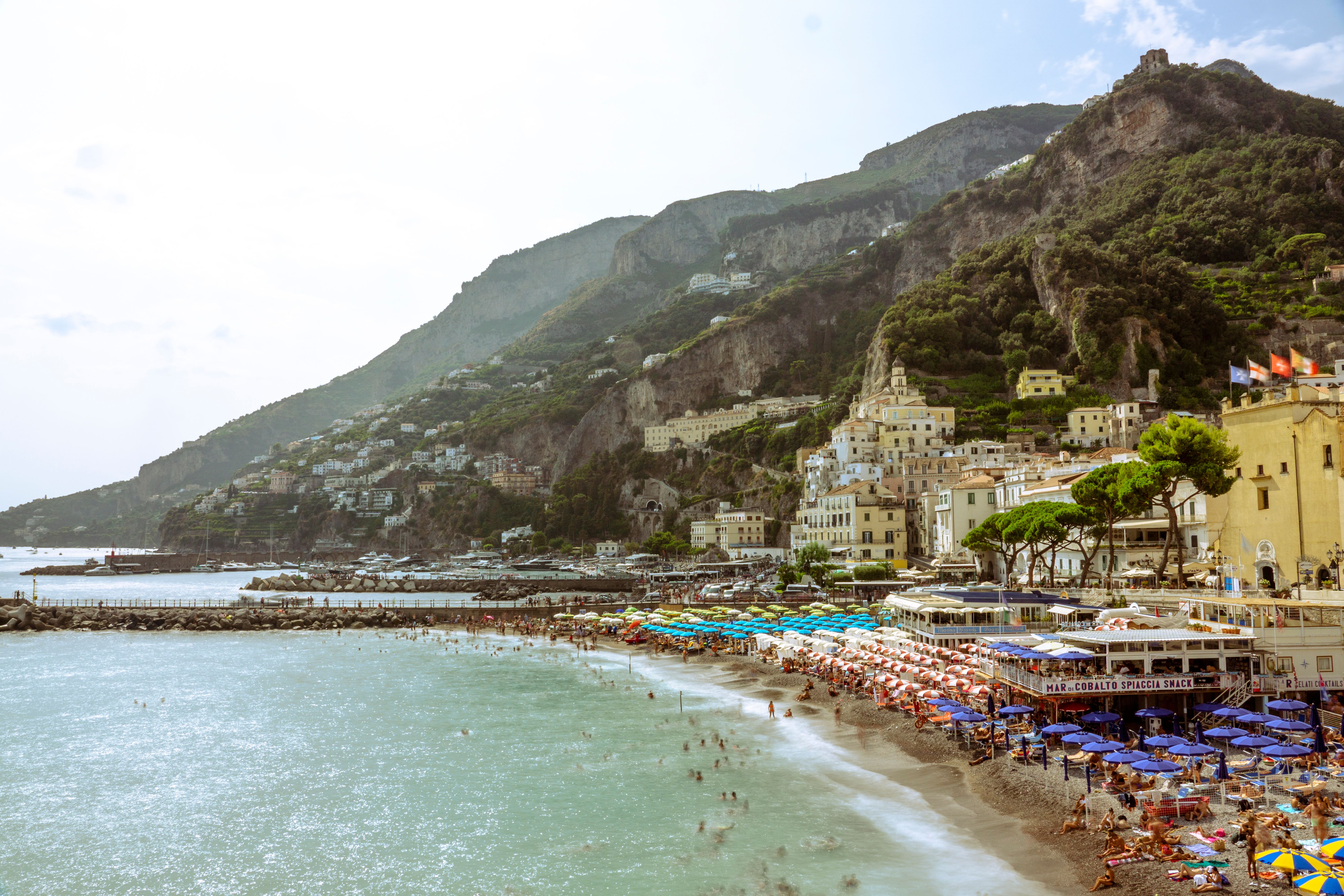 Una playa de la costa amalfitana llena de sombrillas de pago