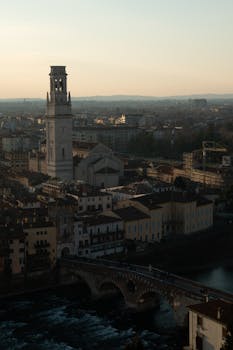 A scenic view of Verona showcasing the Lamberti Tower during sunset, capturing a historic urban landscape.