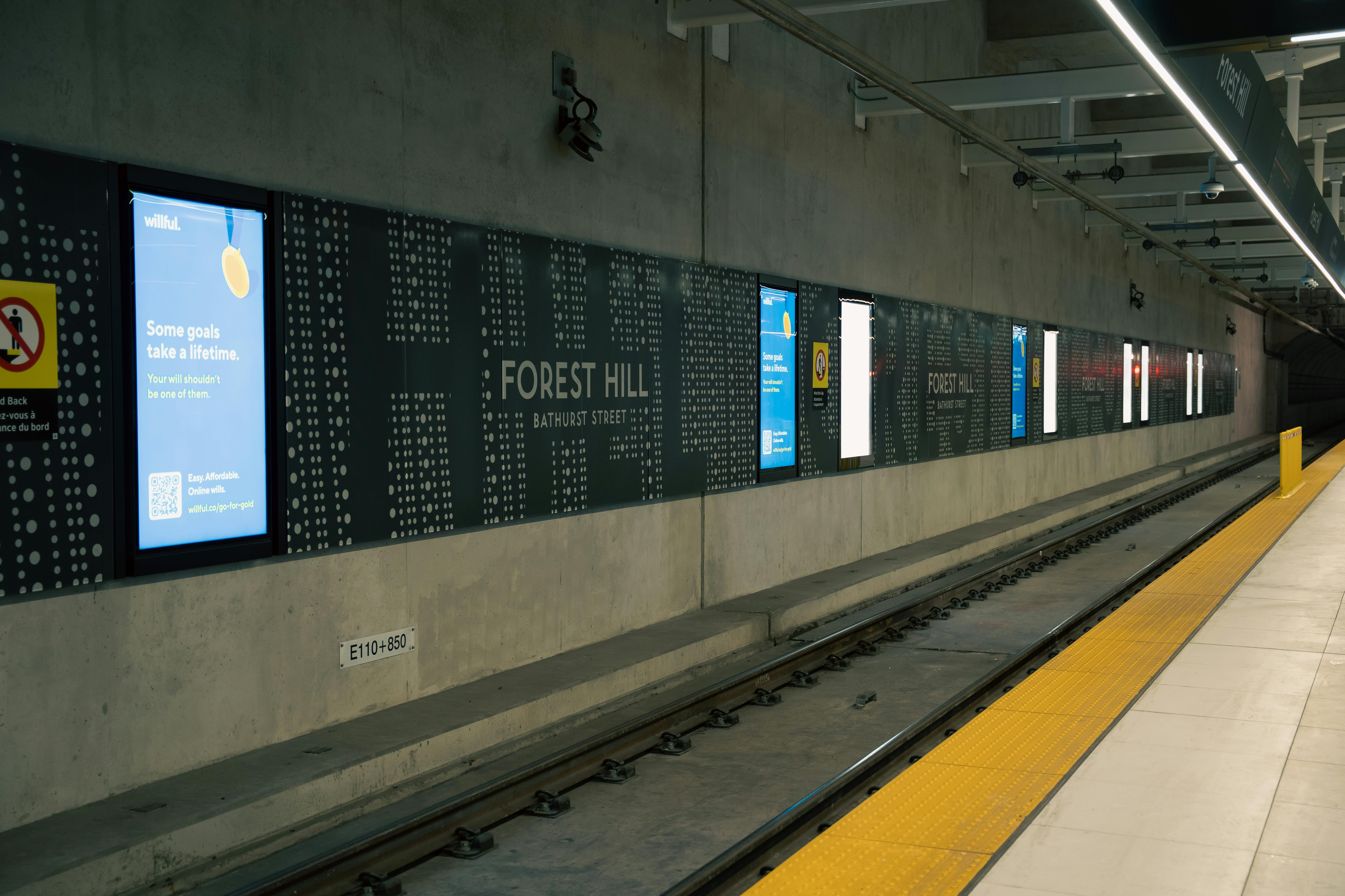 Gratis Utsikt over plattformen til Forest Hill t-banestasjon, med skilt og reklame. Arkivbilde