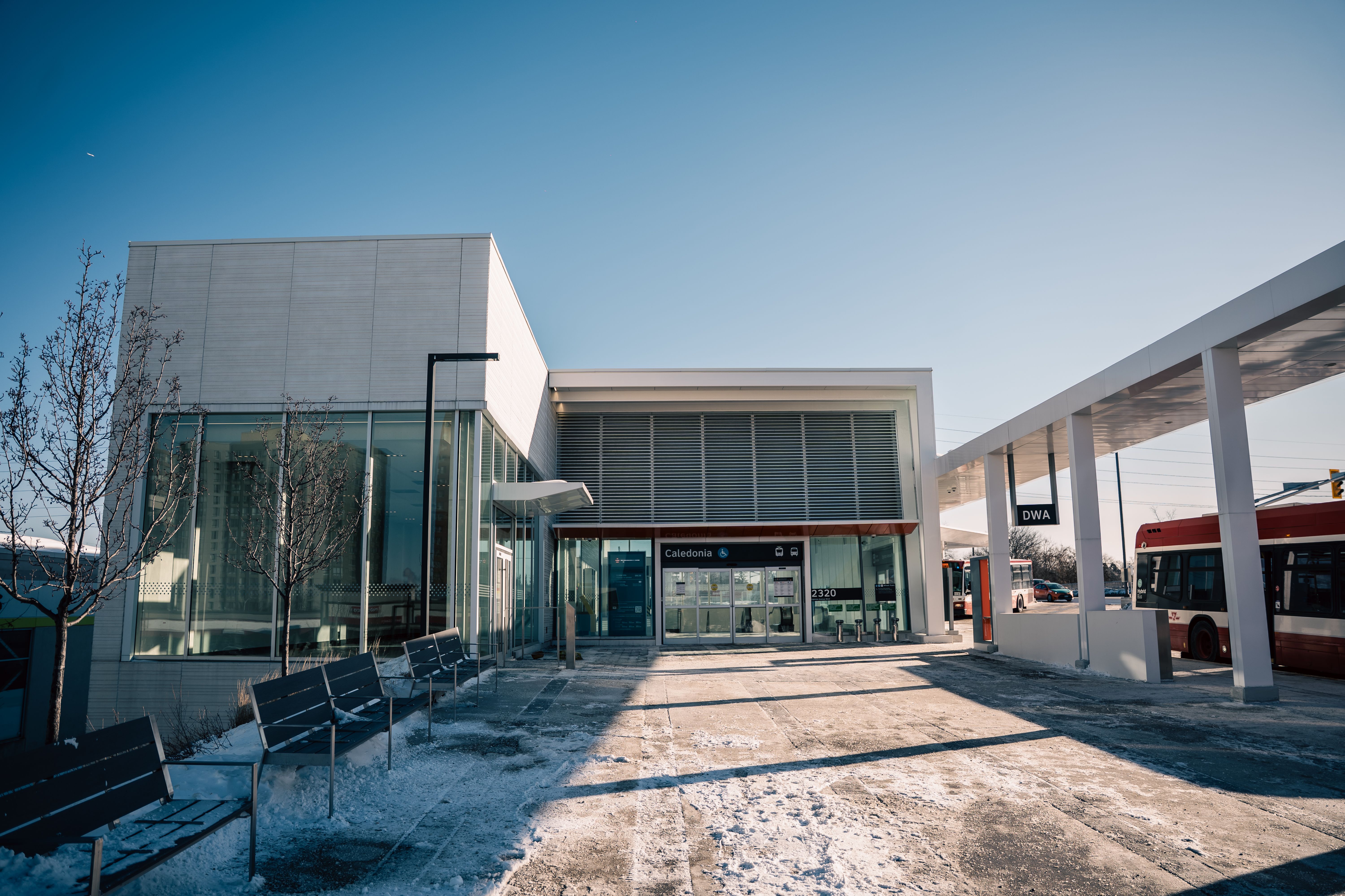 Contemporary transit station exterior under clear blue skies on a sunny winter day.