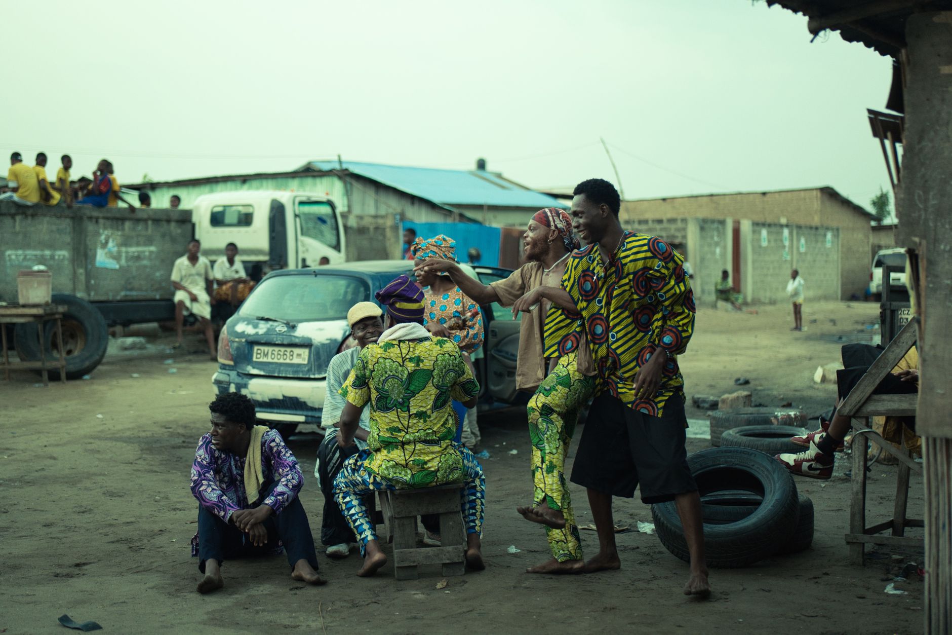 Urban African street scene with people in traditional attire, lively atmosphere.