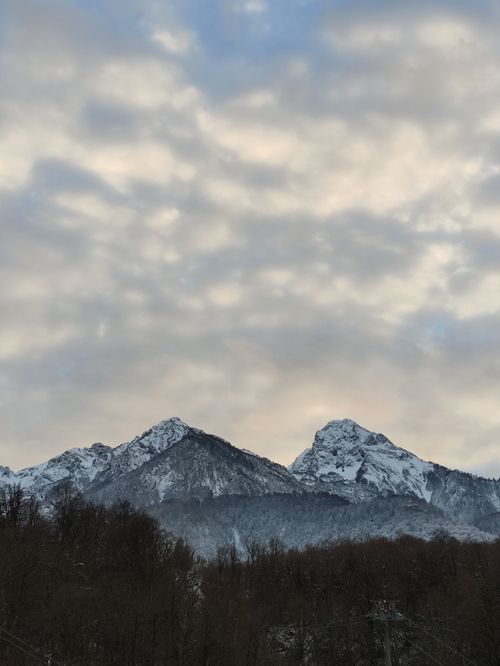Free A serene view of capped mountains with layered clouds in winter. Stock Photo