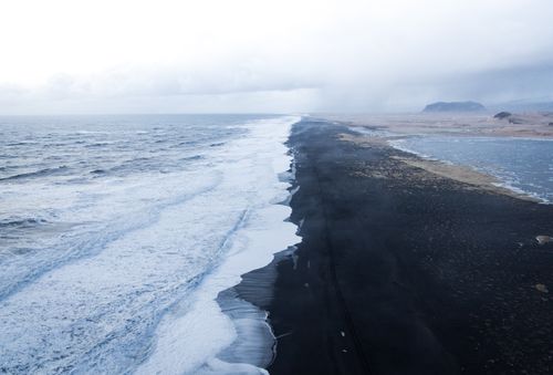 Free A stunning aerial shot of Reynisfjara black sand beach in Vik, Iceland, showcasing the dramatic coastline. Stock Photo