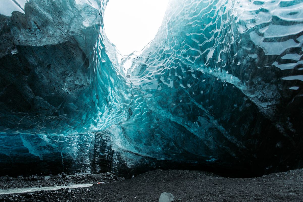 The otherworldly deep-blue interior of an ice cave — the same frozen architecture the ICEHOTEL is carved from each winter