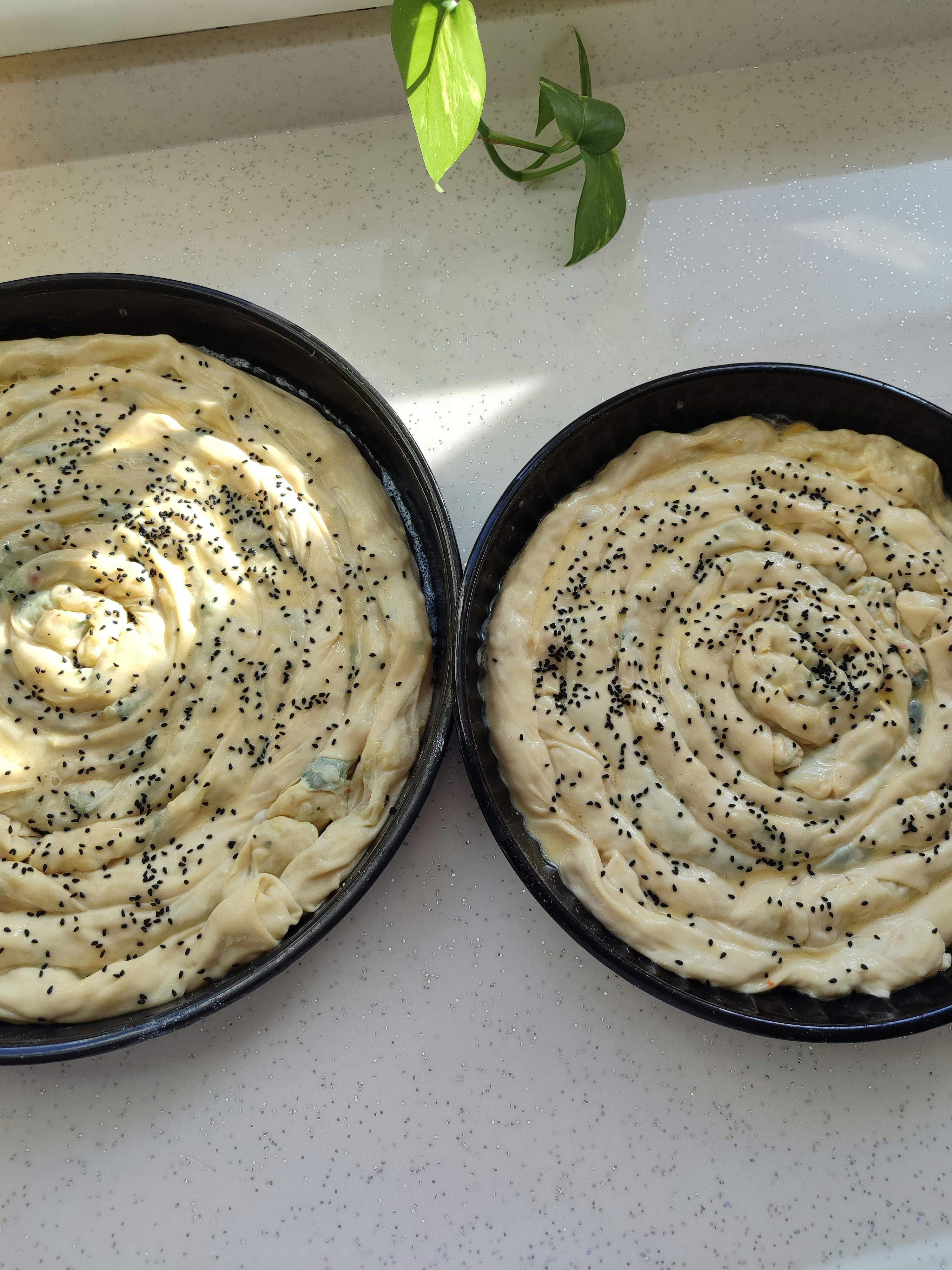 Gratis To runde brett med ustekt spinat og osteborek med sesamfrø. Arkivbilde