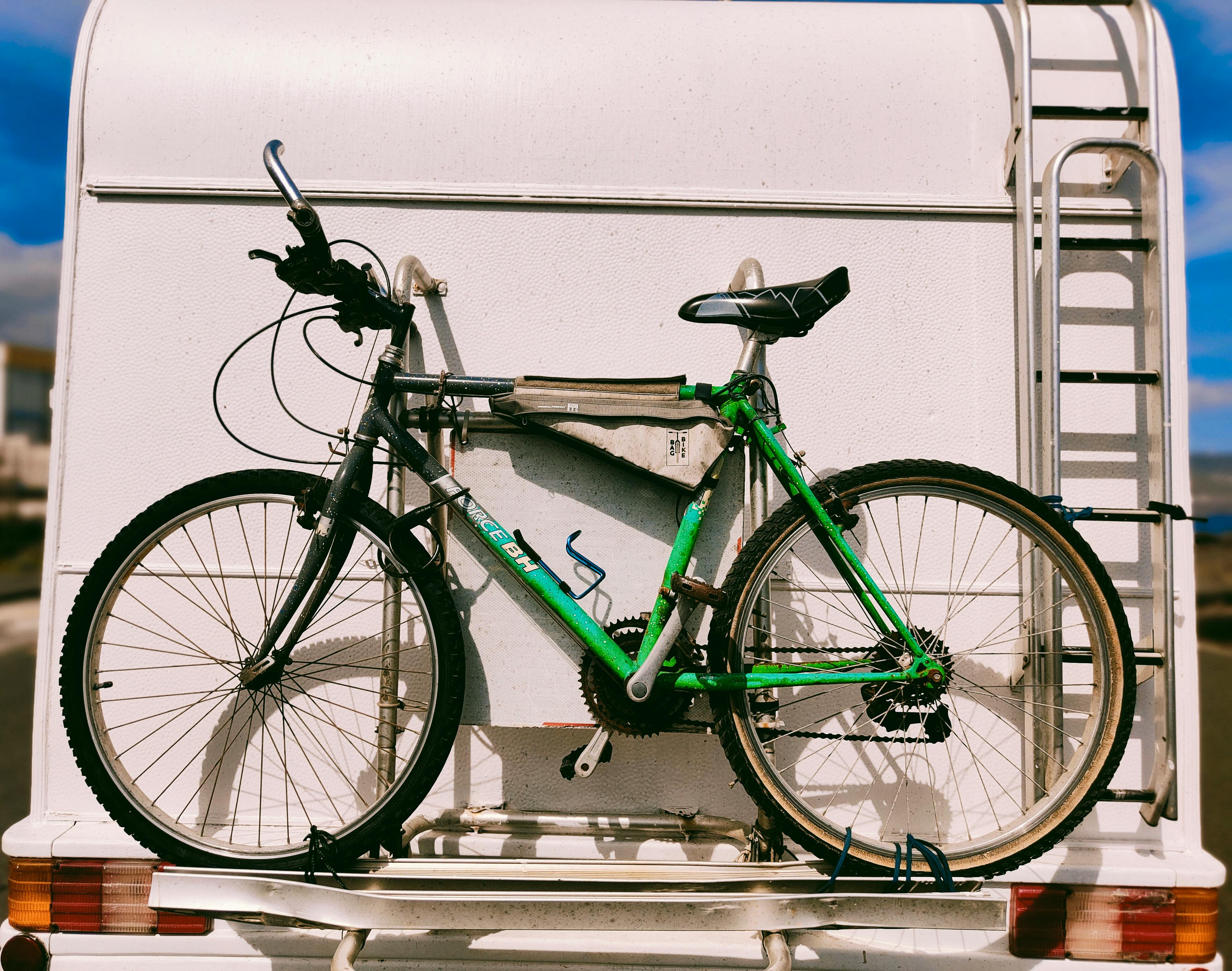 Gratis Grønn sykkel trygt festet bak på en campingvogn, klar for eventyr. Arkivbilde