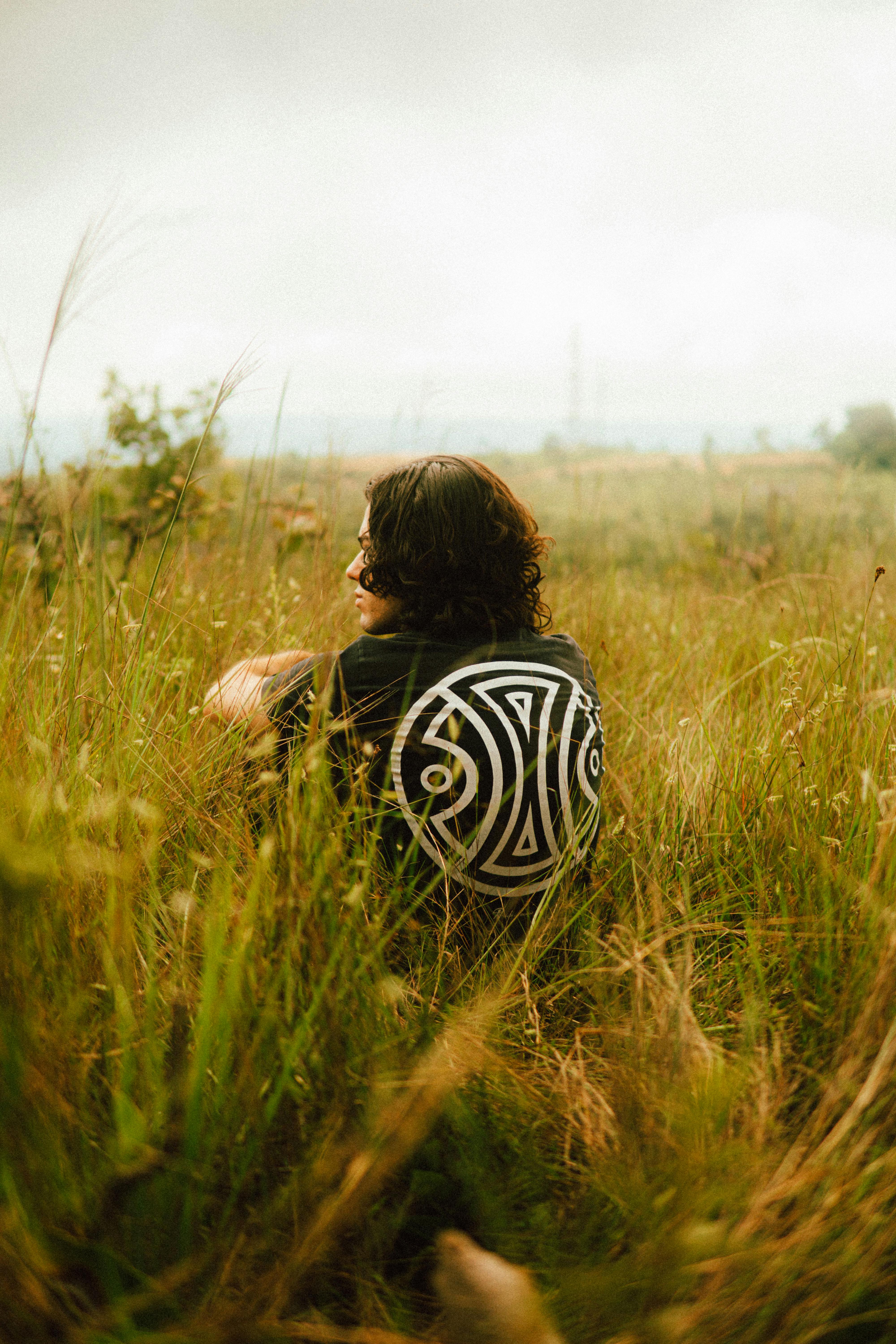 無料 ブラジルのセテ・ラゴアスの草原で静かに座っている男性。 写真素材