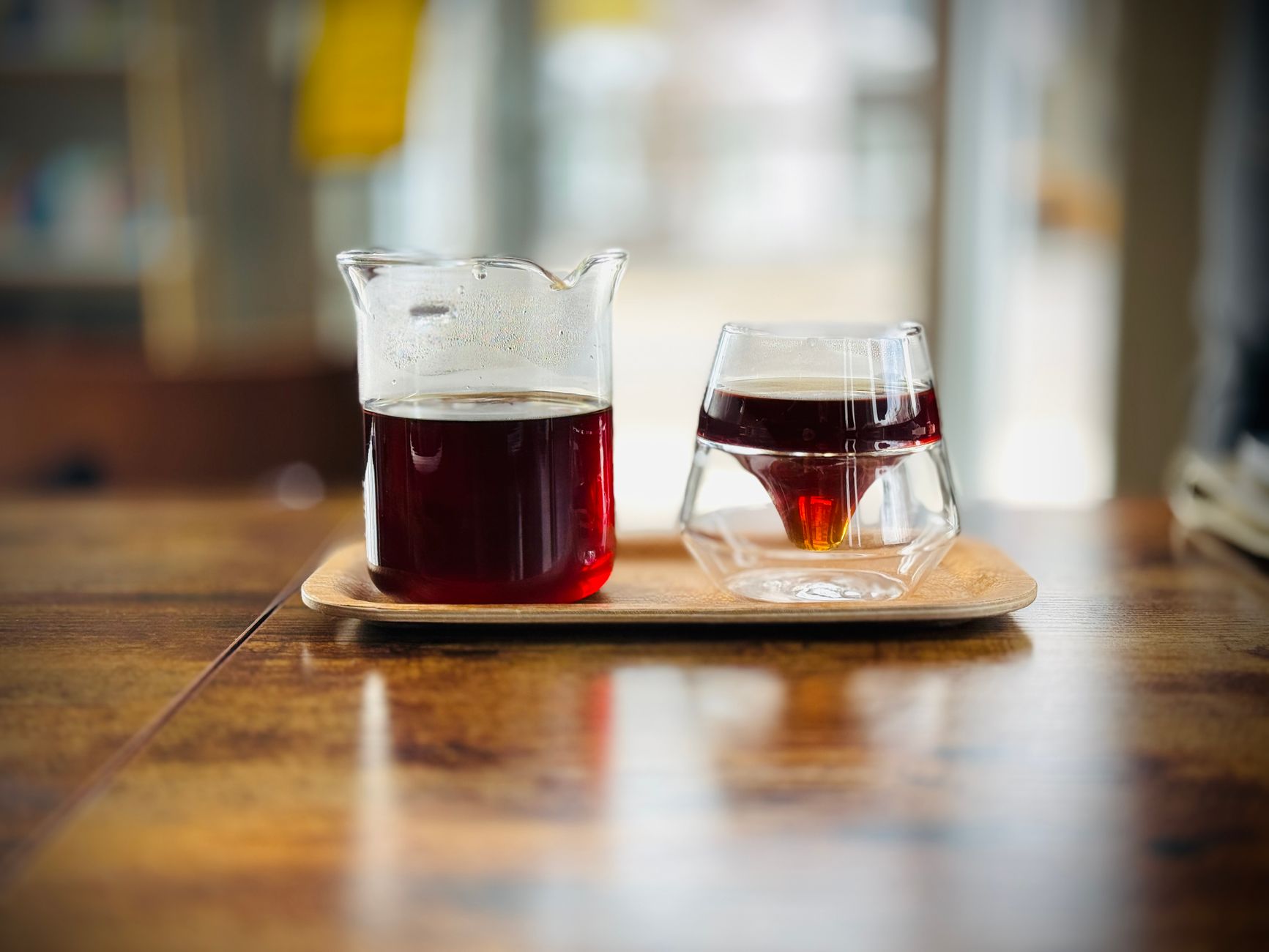 Espresso and pour-over coffee on a wooden cafe table