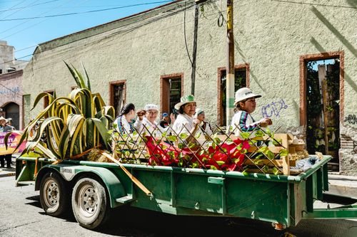 Free Colorful parade float with people in traditional attire and agave plants in Pachuca, Mexico. Stock Photo