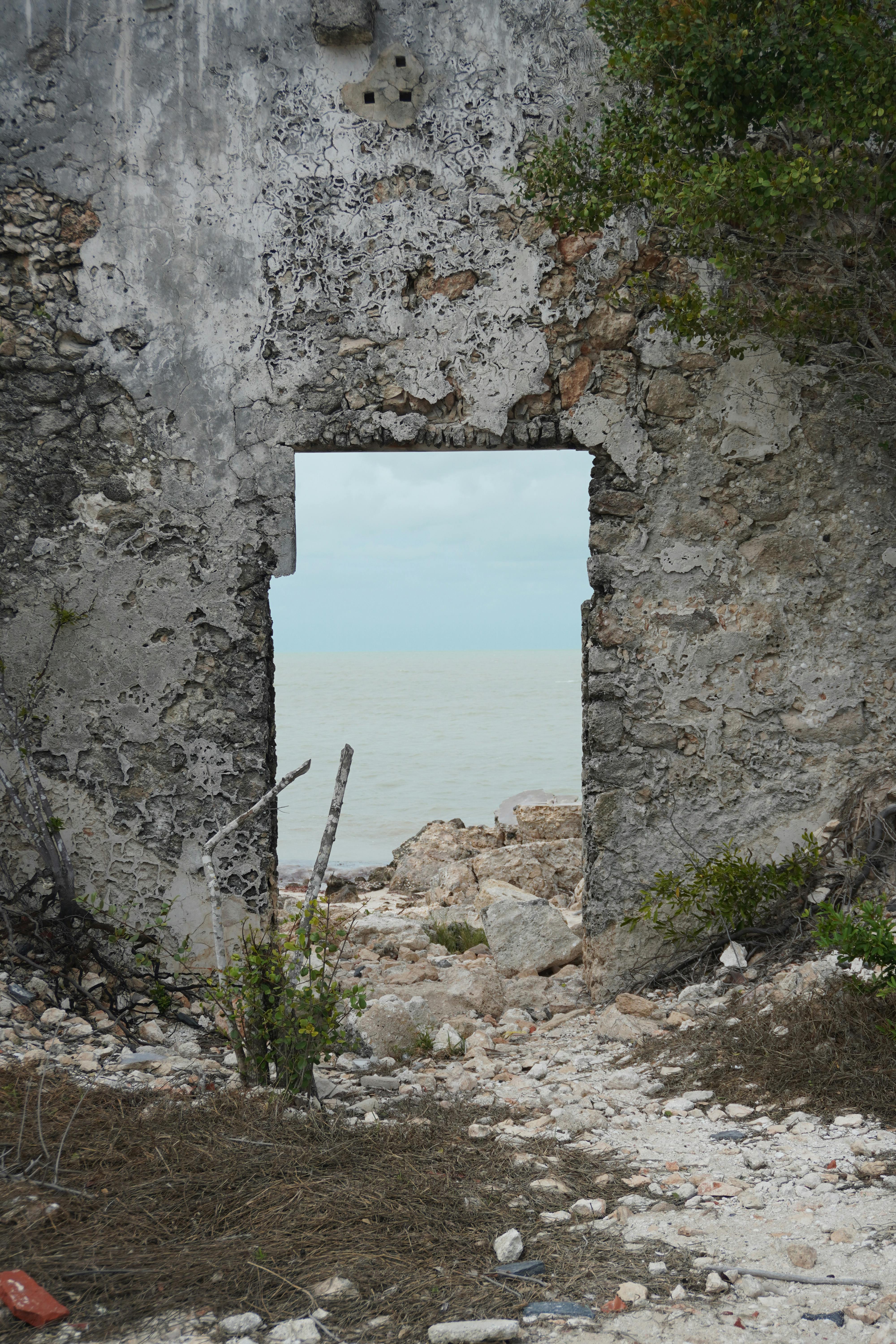 Kostnadsfria Förstörd stenmur med havsutsikt i Yucatán, Mexiko, som förmedlar en atmosfär av förfall och natur. Stock foto