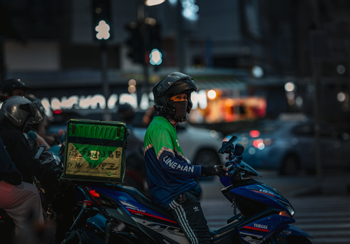 Free Food delivery rider on motorbike at night in Bangkok, Thailand. Stock Photo