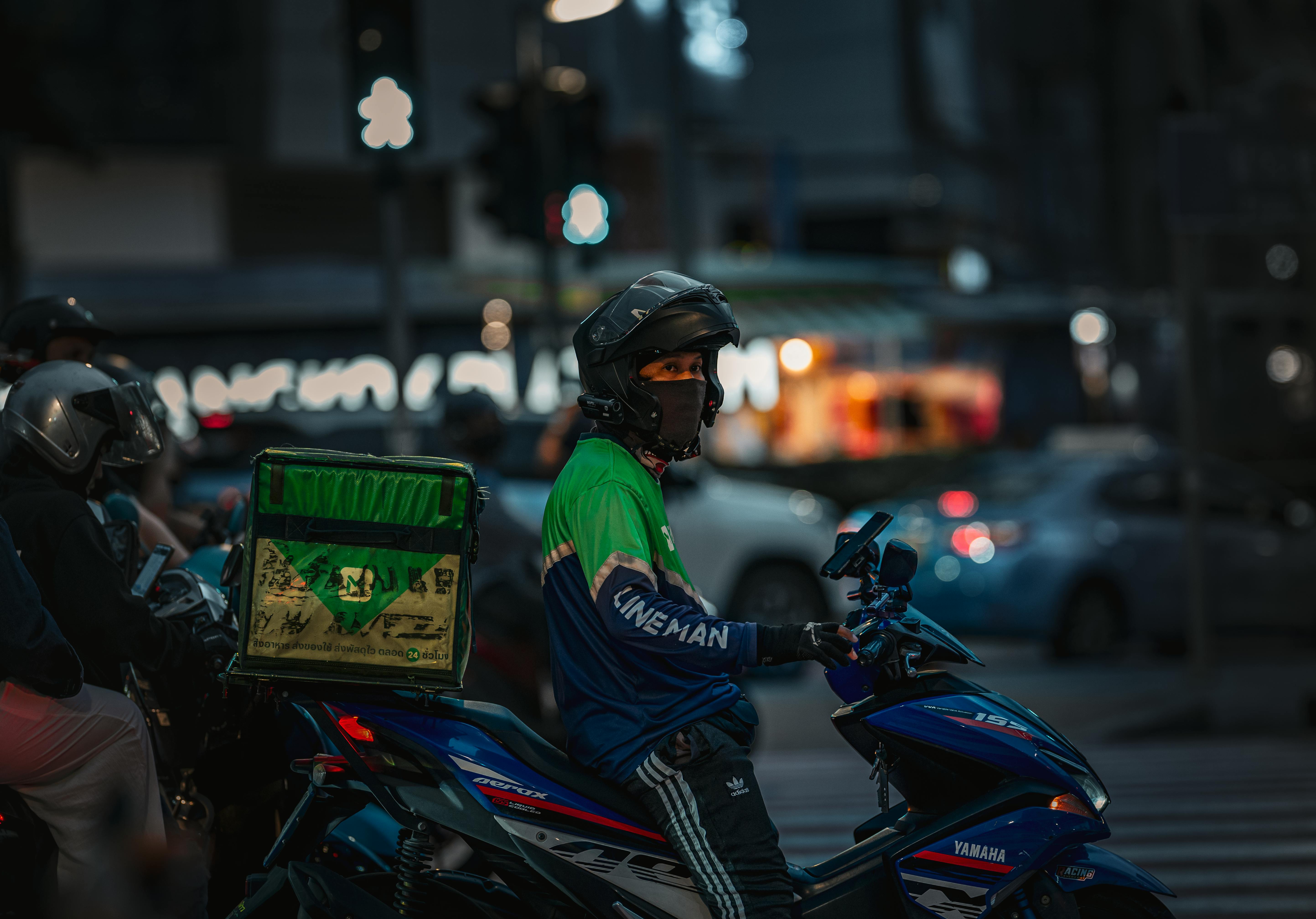Gratis Repartidor de comida en motocicleta por la noche en Bangkok, Tailandia. Foto de stock
