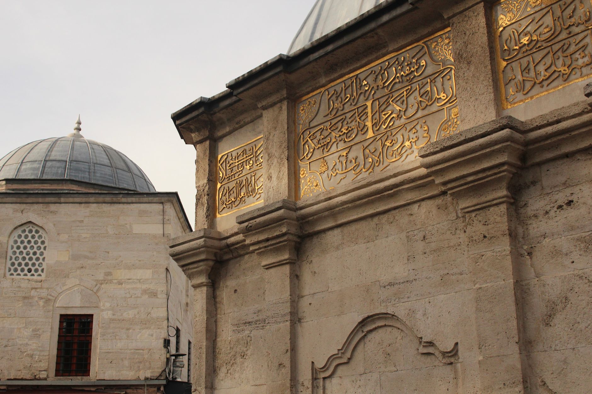Capture of ancient Islamic architecture showcasing beautiful Arabic calligraphy on stone walls.