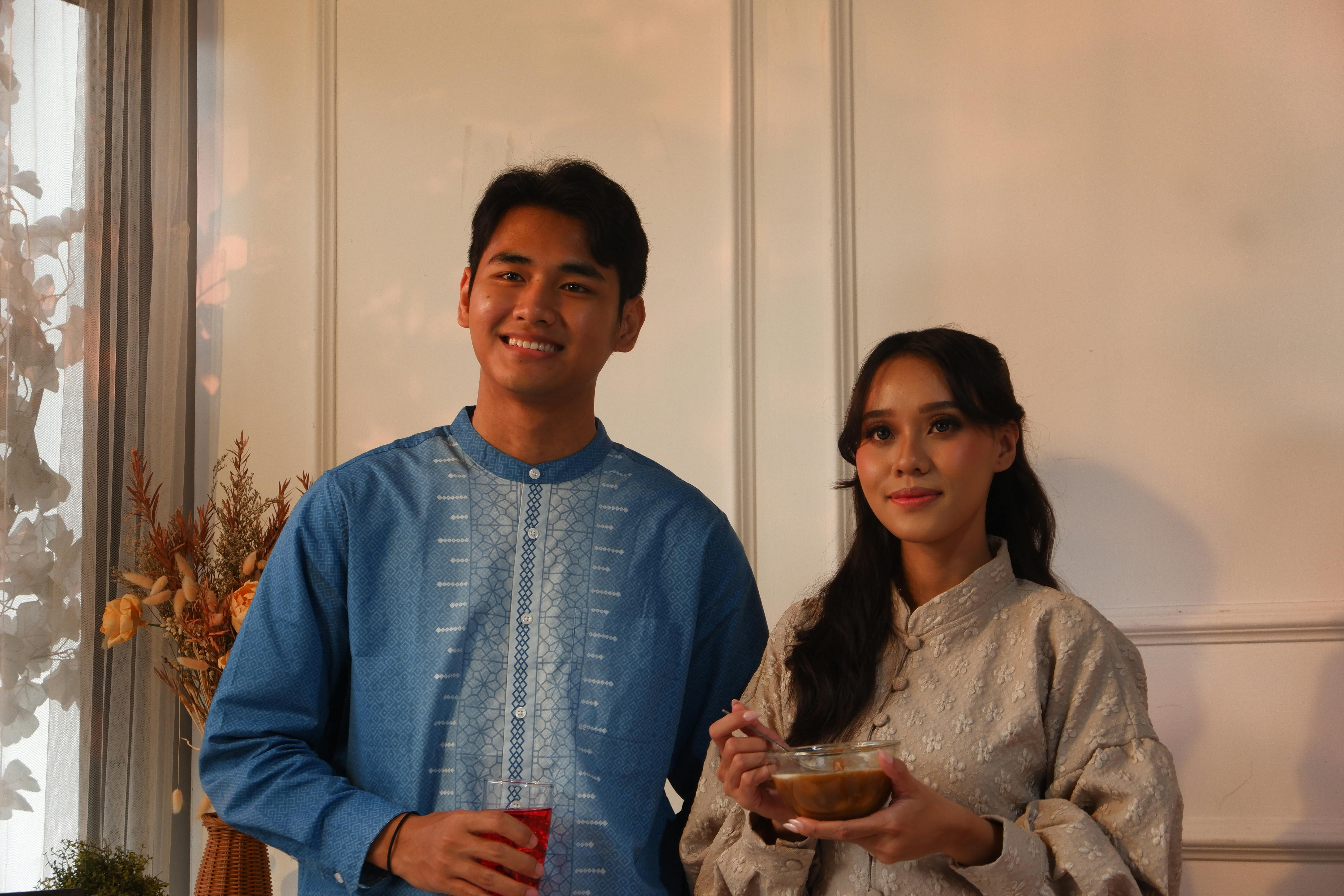 Δωρεάν Ένα ζευγάρι με παραδοσιακή ενδυμασία απολαμβάνει ένα γεύμα σε εσωτερικό χώρο με απαλό φωτισμό. Φωτογραφία από στοκ φωτογραφιών