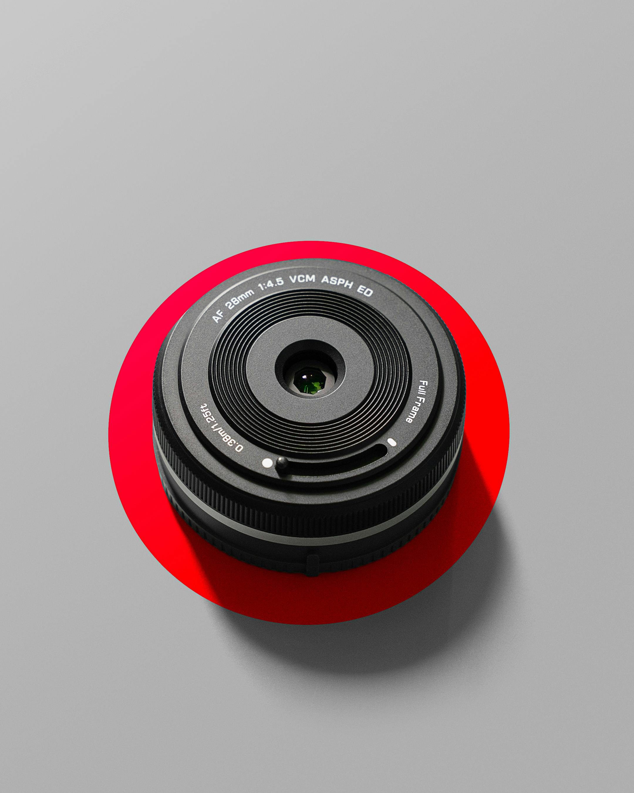 Gratis Foto minimalista di un obiettivo fotografico su uno sfondo rosso e grigio. Foto a disposizione