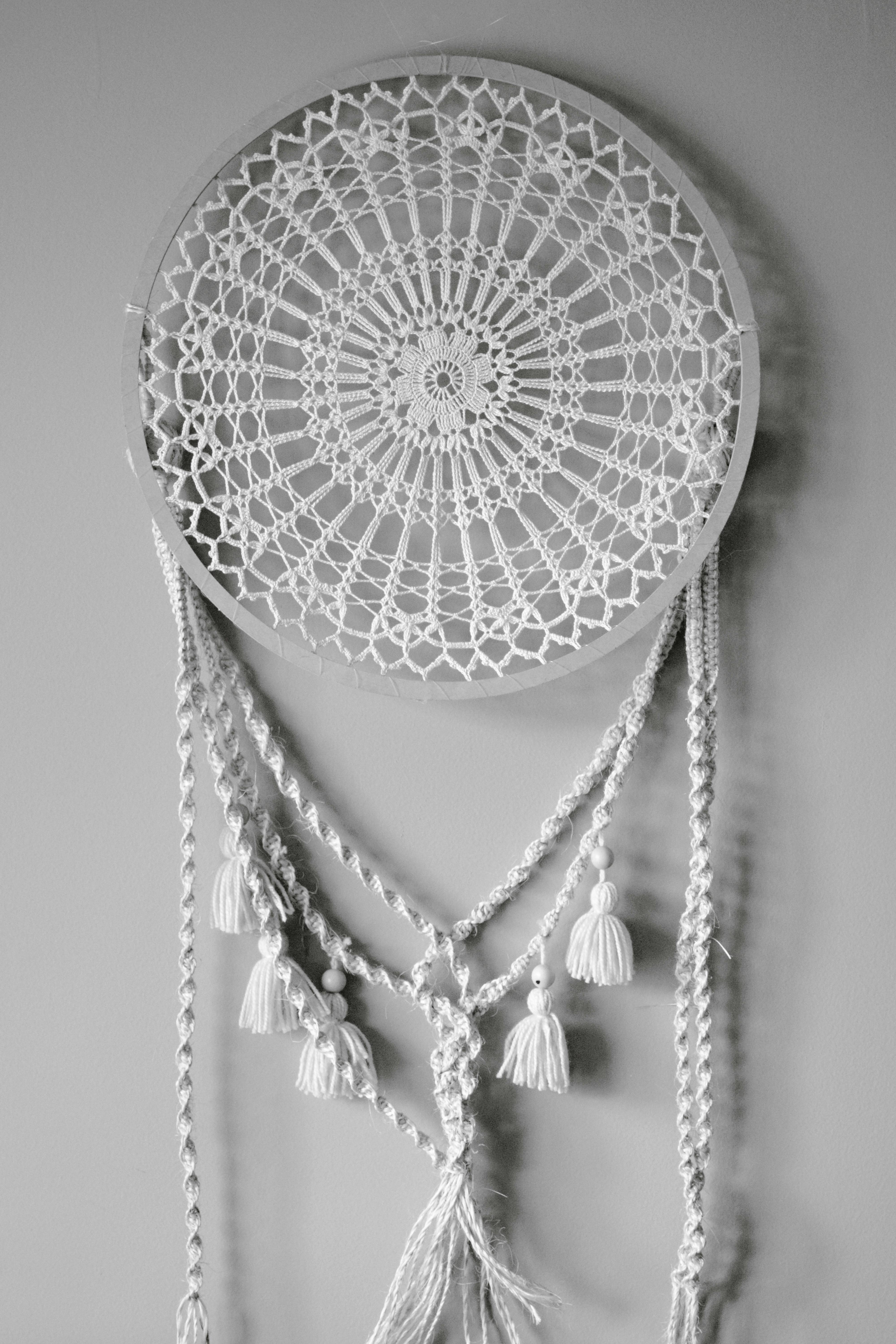 Безкоштовне Стильний в'язаний гачком ловець снів з китицями на сірій стіні. Ідеальний елемент декору в богемному стилі. стокове фото