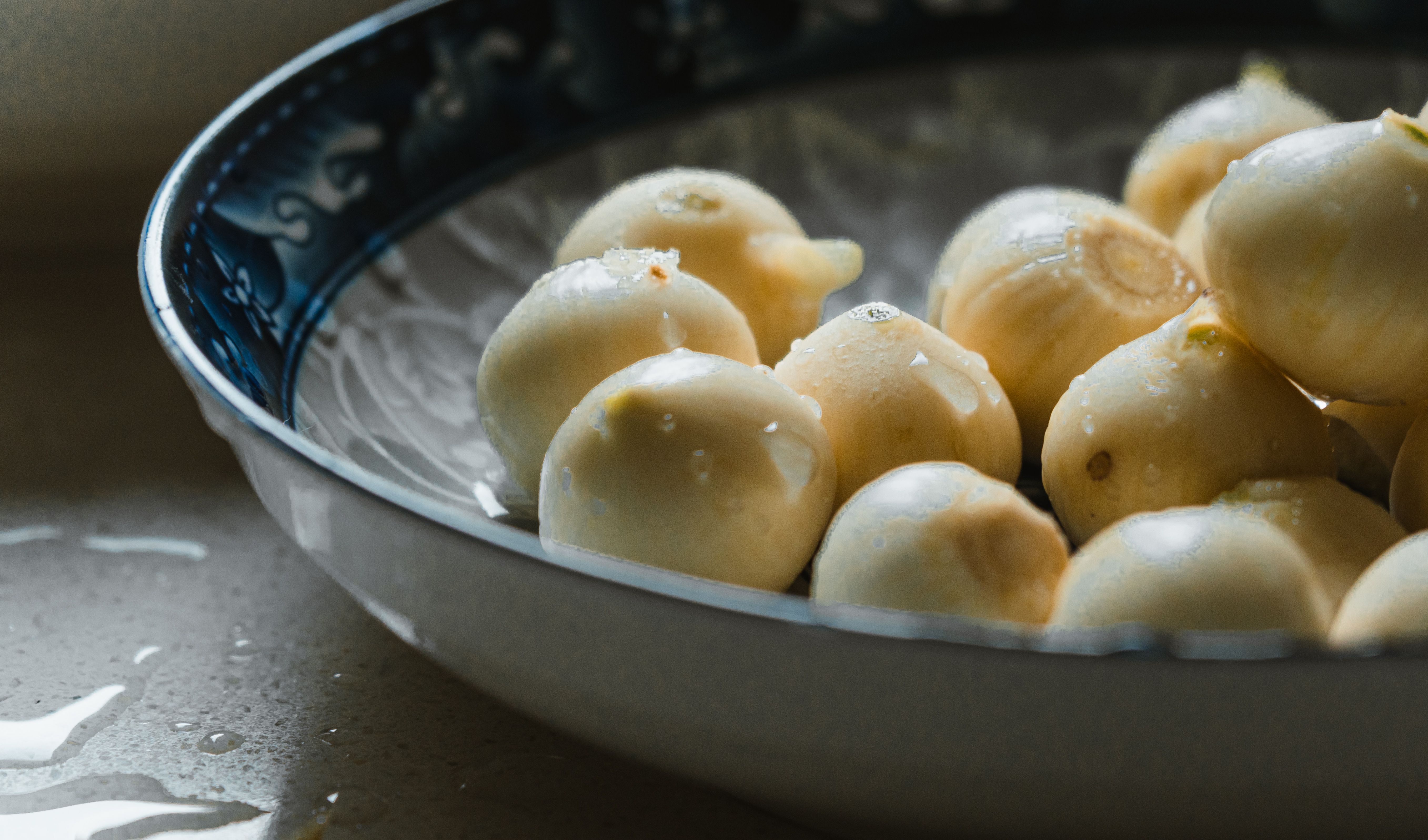 Free Close-up of fresh water chestnuts in a decorative porcelain bowl with natural lighting. Stock Photo