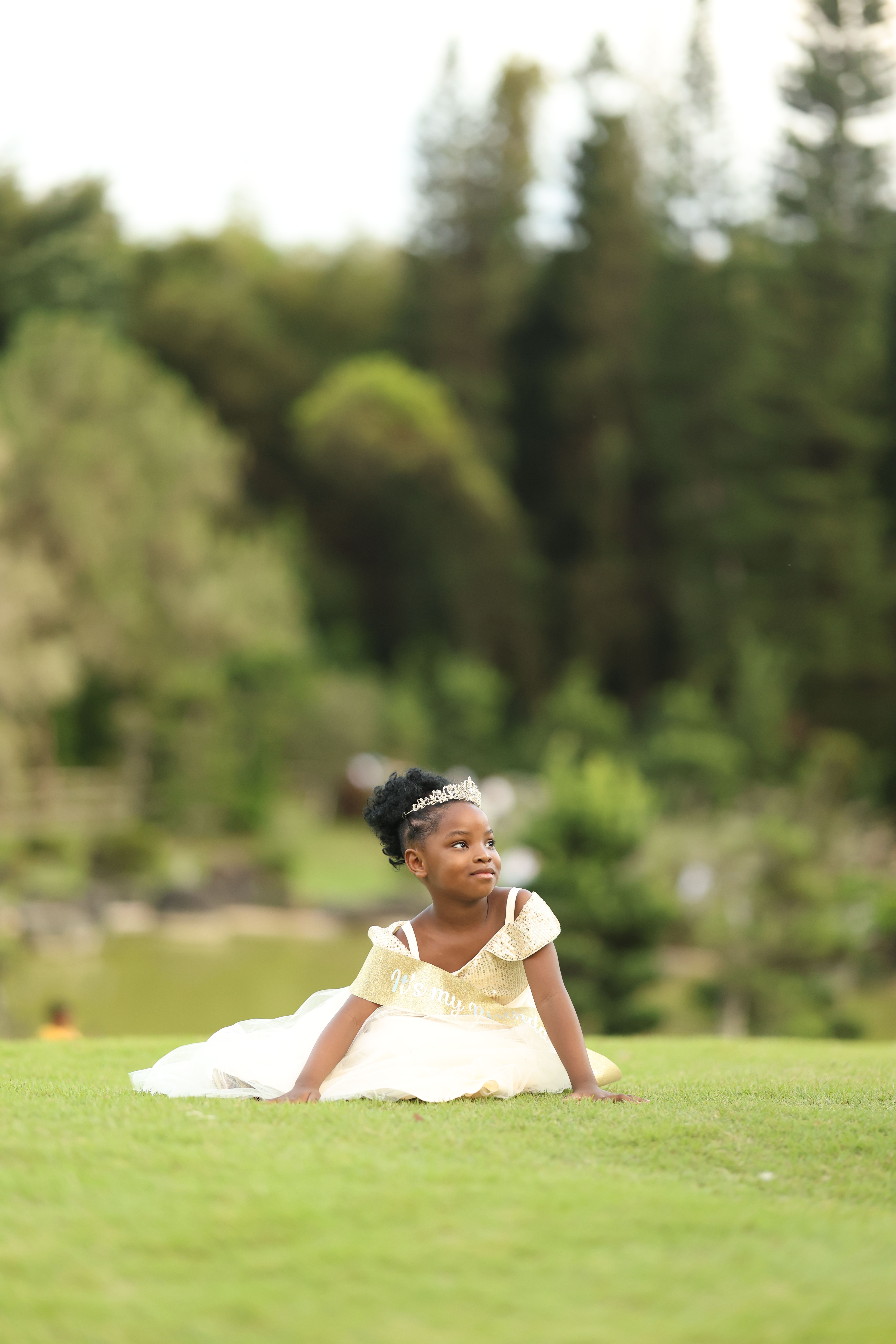 Charming Child in White Dress on Lush Green Lawn · Free Stock Photo
