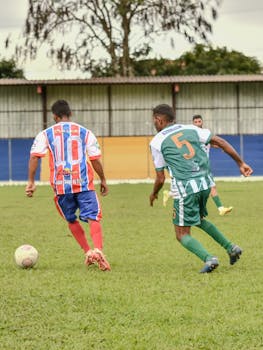 Soccer players in vibrant uniforms engaged in a lively match on a grass field.