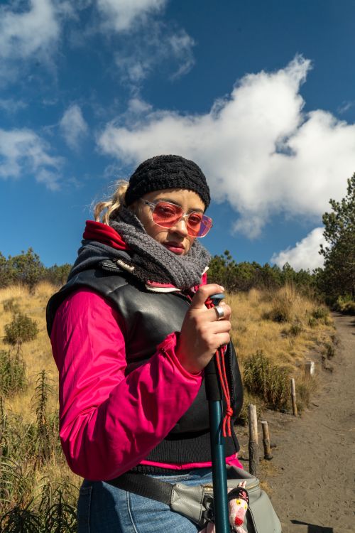 Free Woman in winter attire hiking under clear blue skies. Stock Photo