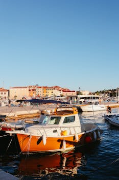A picturesque harbor with colorful boats and vibrant buildings during sunset.