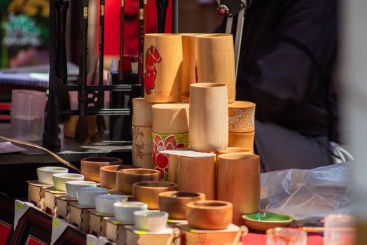 A close-up of a stack of wooden cups displayed at an outdoor market stall, showcasing handcrafted artistry.