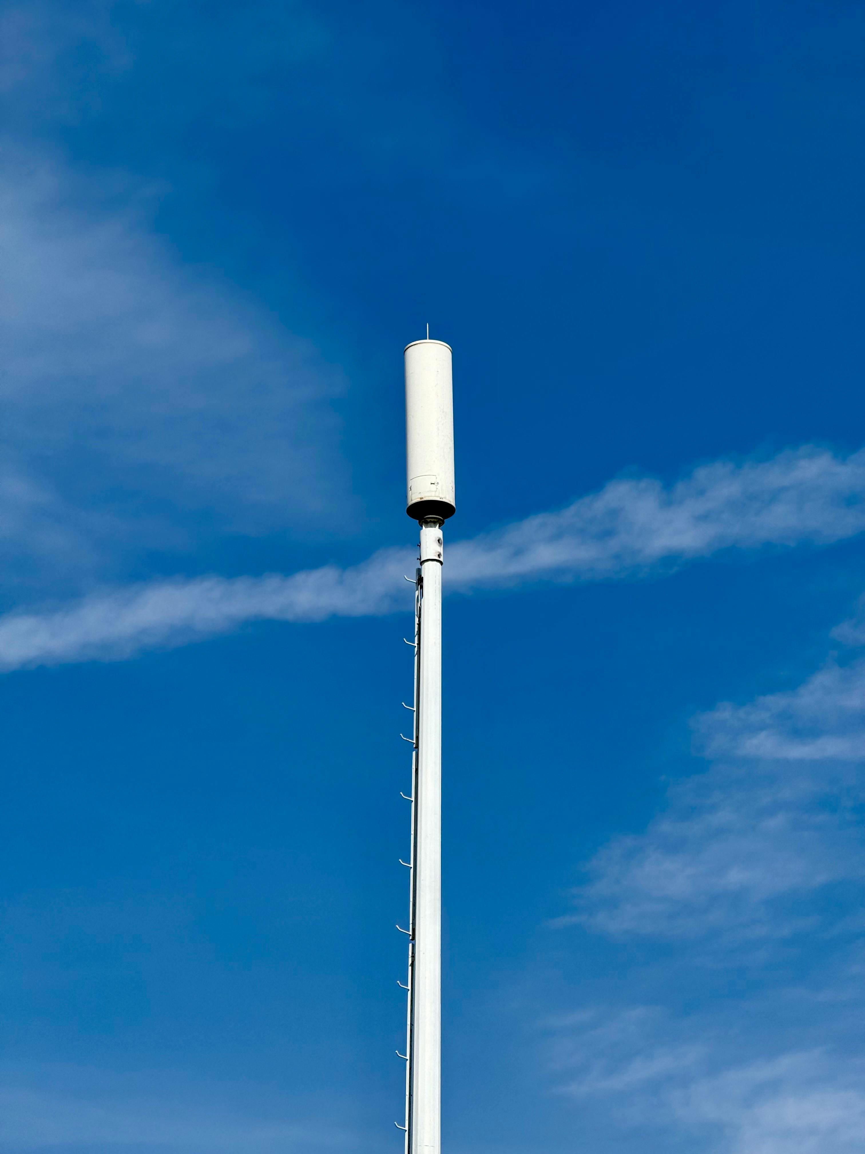 Безкоштовне Висока вежа стільникового зв'язку на тлі чистого блакитного неба символізує зв'язок та технології. стокове фото