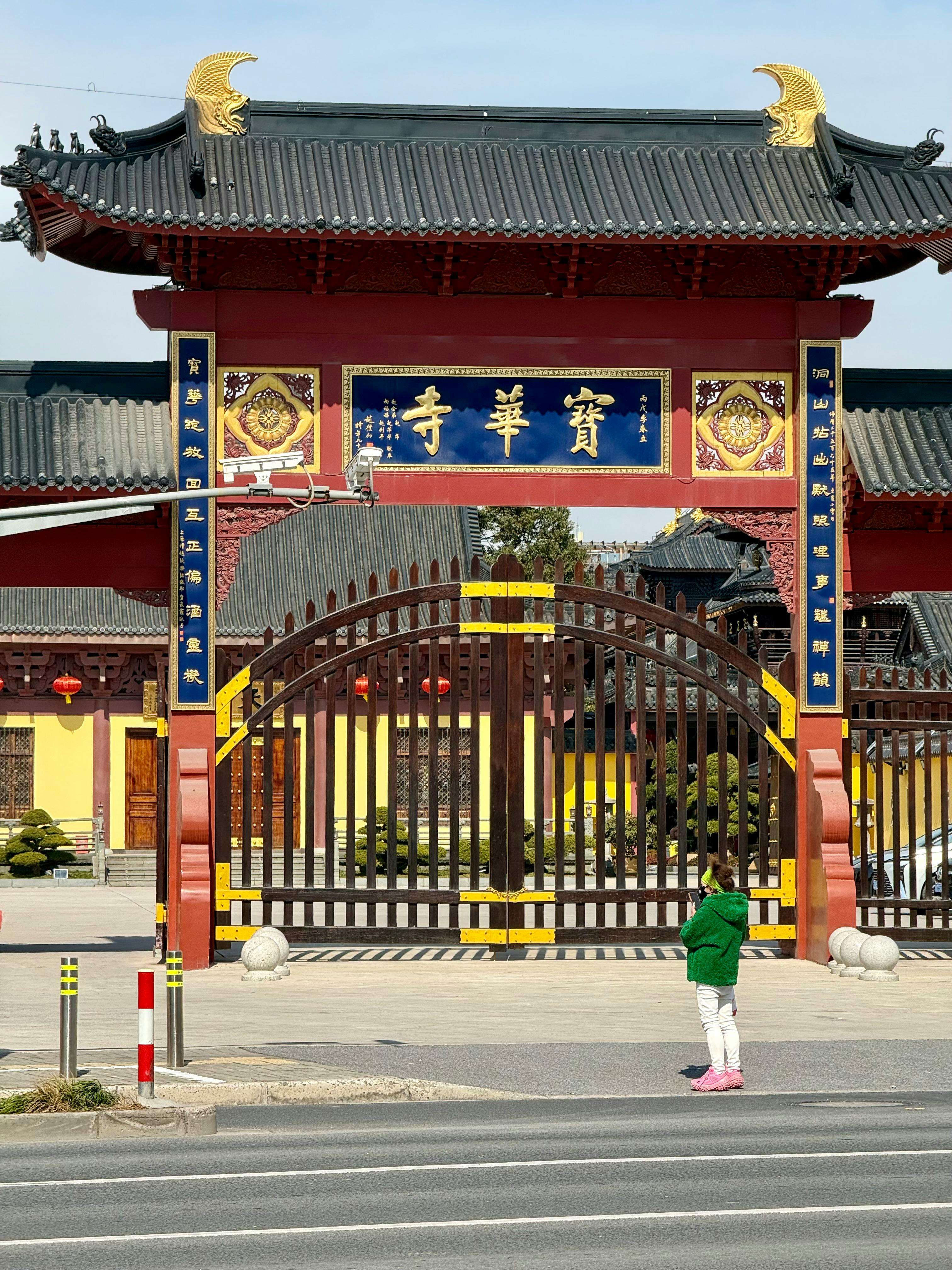ingyenes Egy gyermek áll a sanghaji Baohua templom díszes kapuja előtt, kiemelve a hagyományos kínai építészetet. Stockfotó
