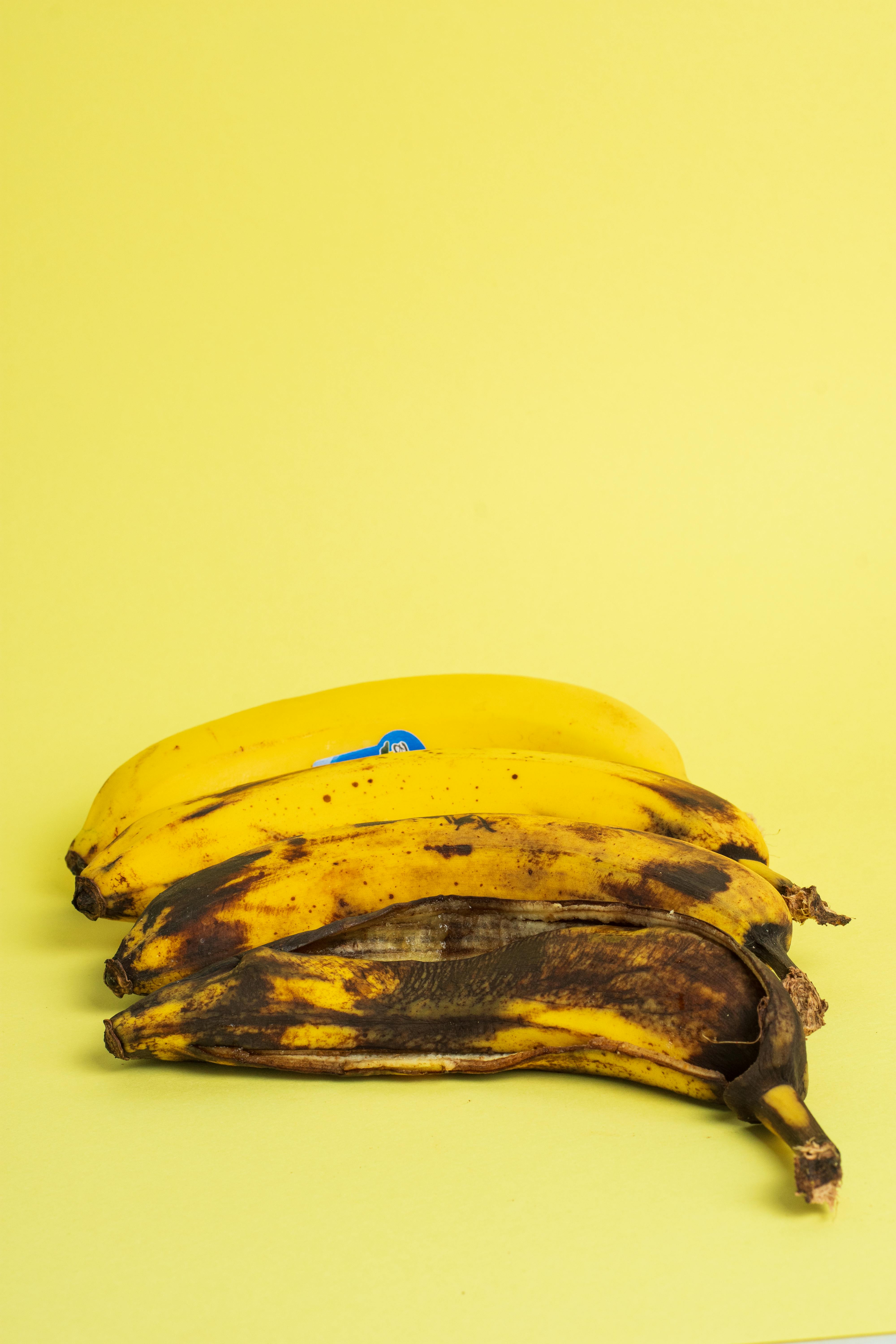 gratis Levendig stilleven van rijpe bananen tegen een heldergele achtergrond. Stockfoto