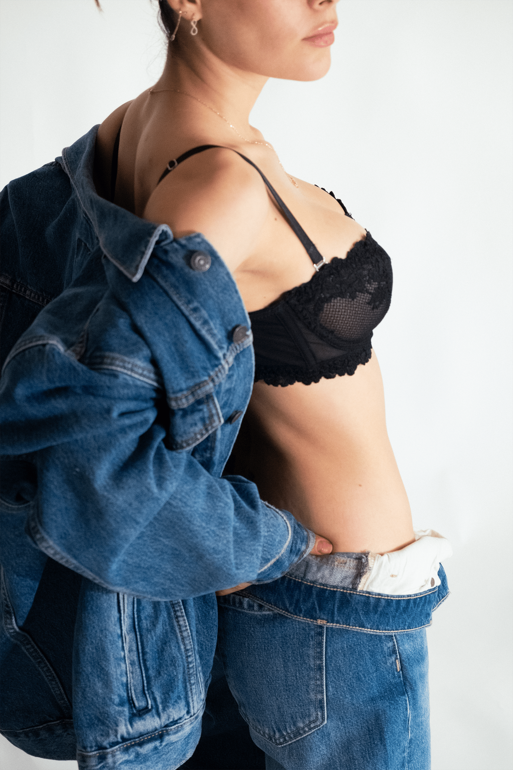 Gratis Una donna elegante posa in jeans e lingerie, sfoggiando la moda moderna. Foto a disposizione