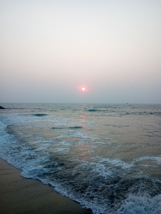 Serene Coastal Sunset Over Calm Ocean Waves · Free Stock Photo