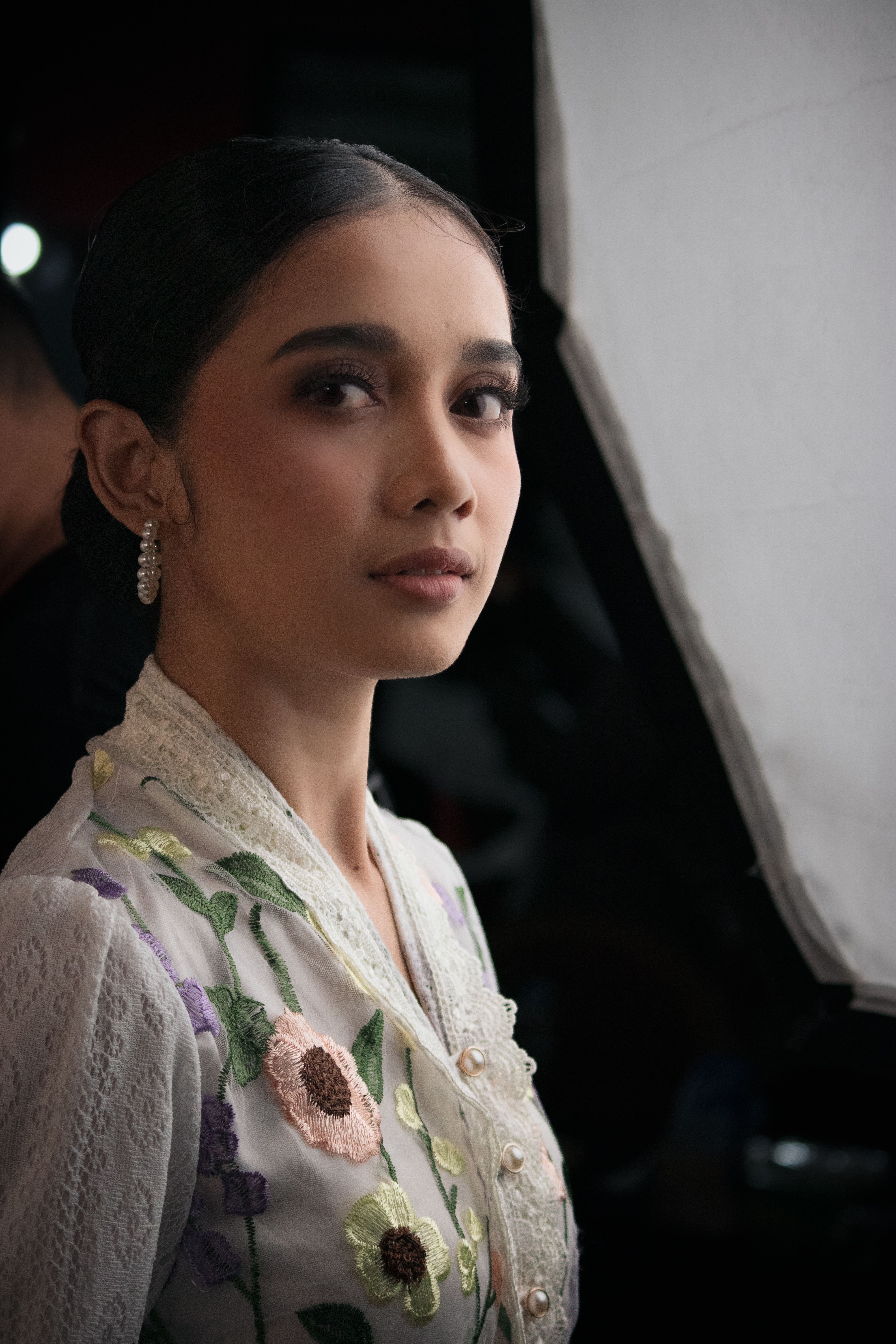 Portrait of a woman in Indonesian attire under studio lighting, exuding grace and elegance.