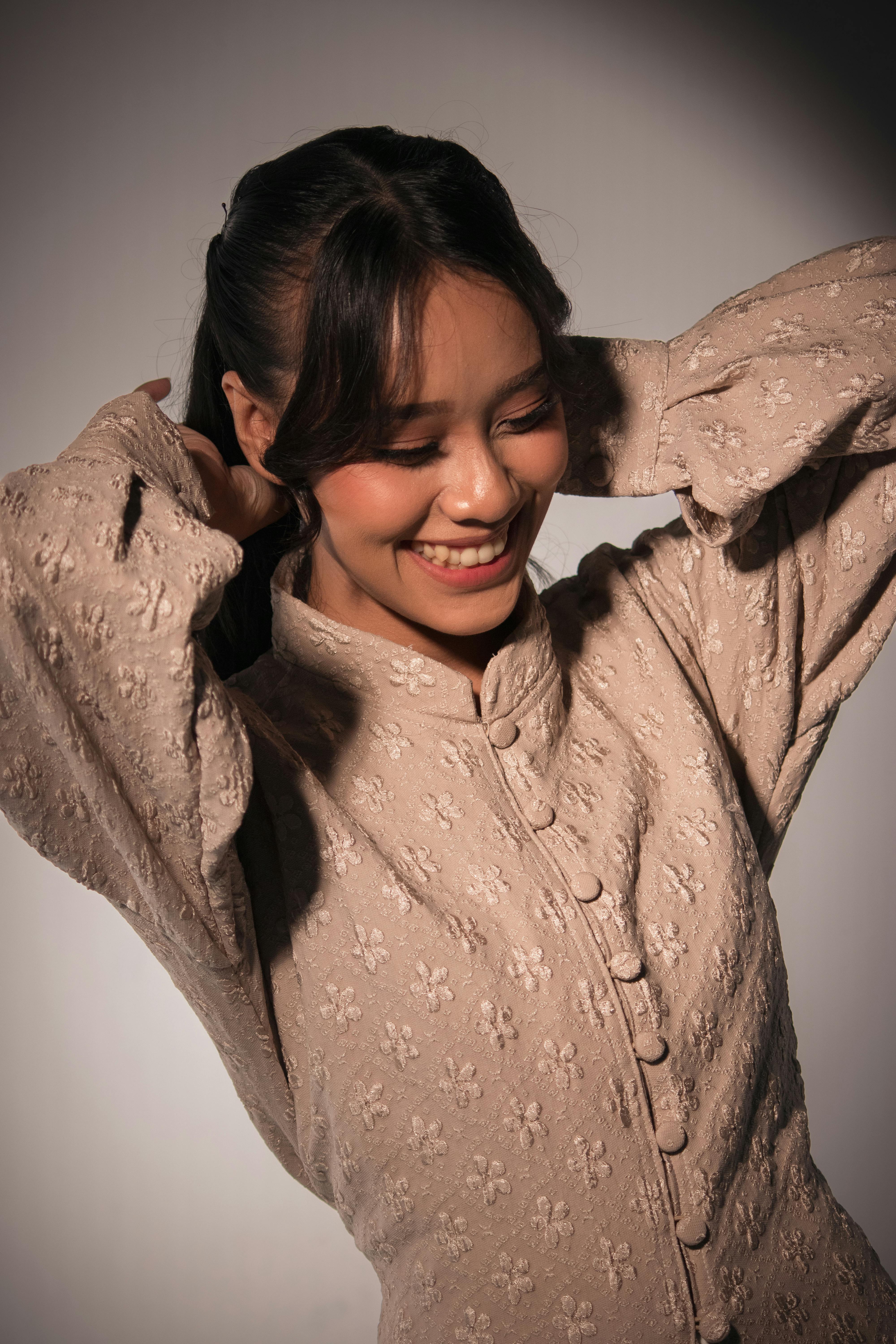 免费 室内拍摄的年轻女子身着印尼传统服饰，面带微笑的肖像照。 素材图片