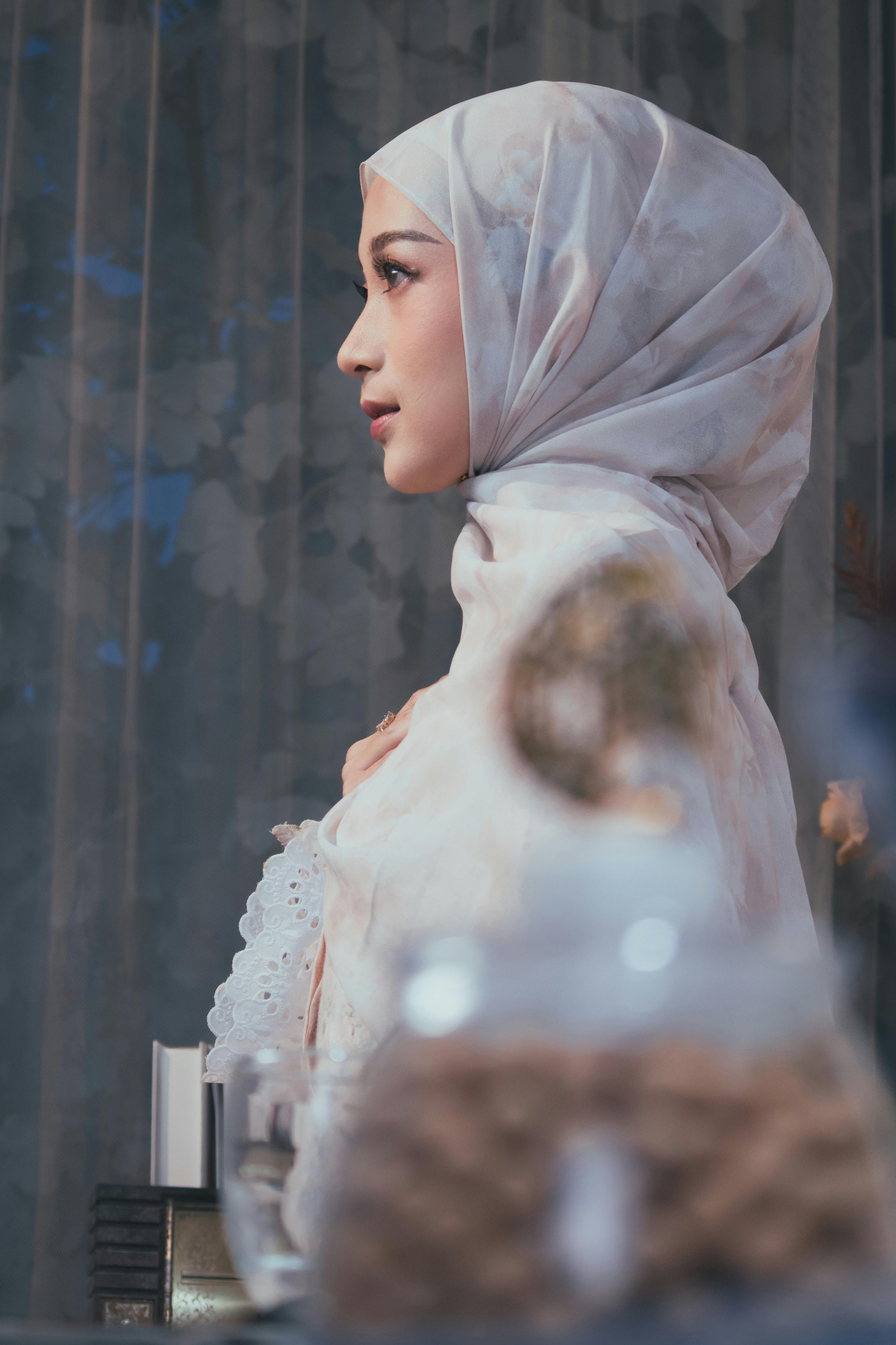 gratis Elegant zijprofielportret van een vrouw die binnenshuis een hijab draagt, waarmee ze culturele schoonheid en gratie uitstraalt. Stockfoto