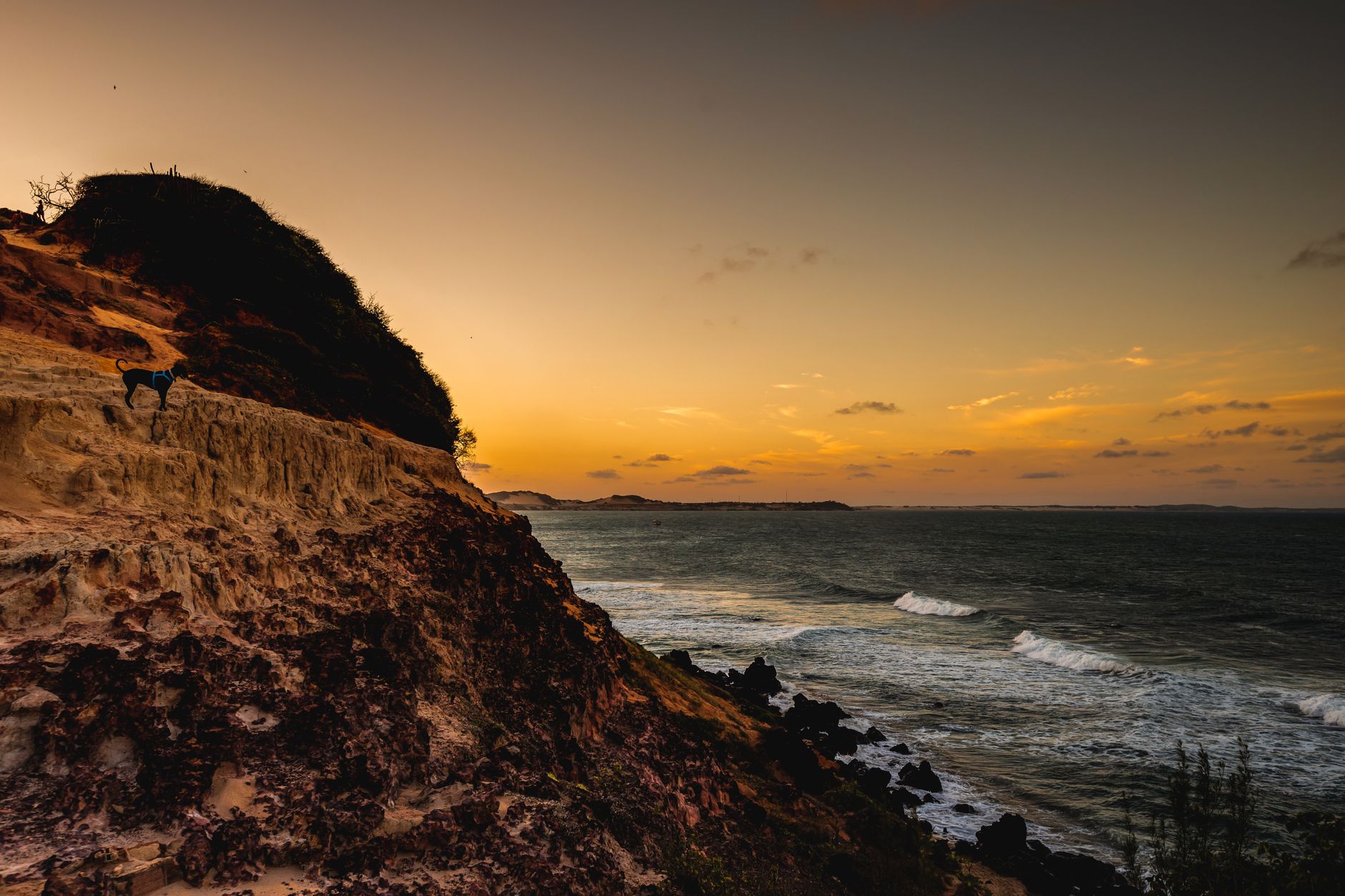Dramatic sunset over the ocean with rugged cliffs in RN, Brazil.