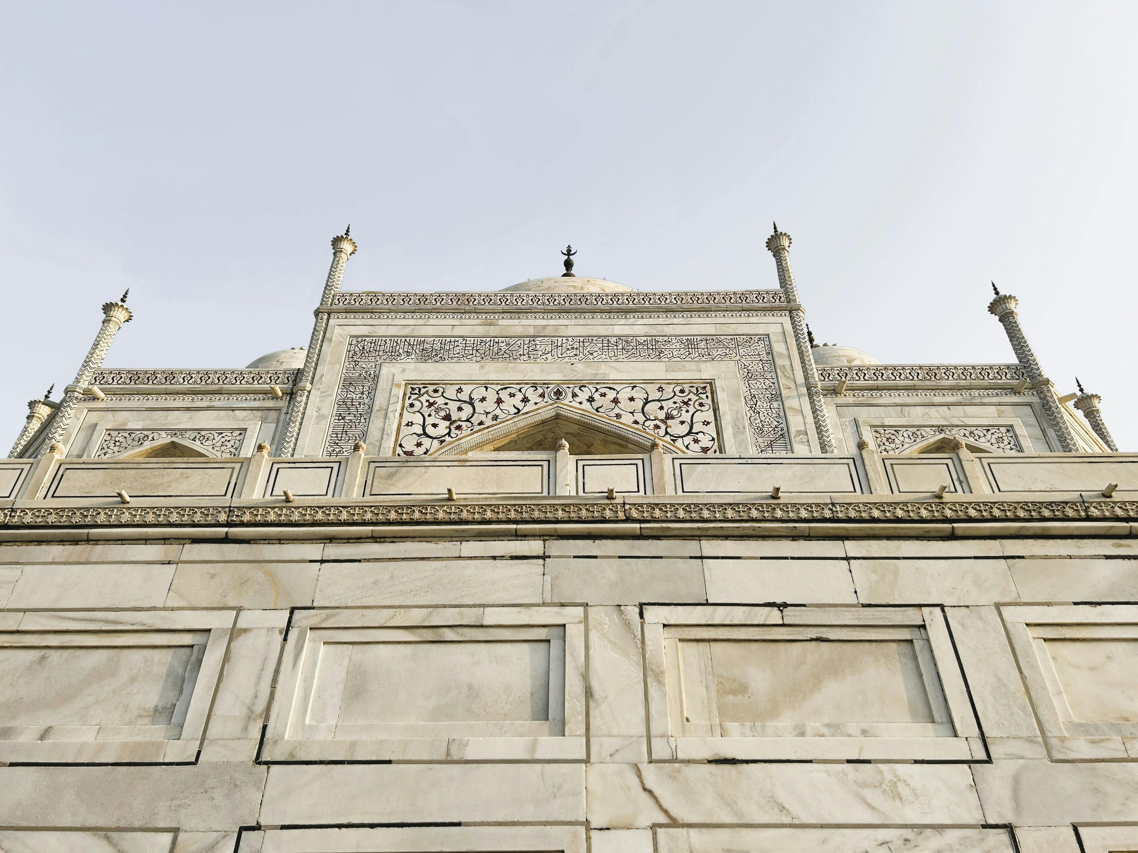 Close-up shot capturing the intricate marble facade of the iconic Taj Mahal with architectural details.