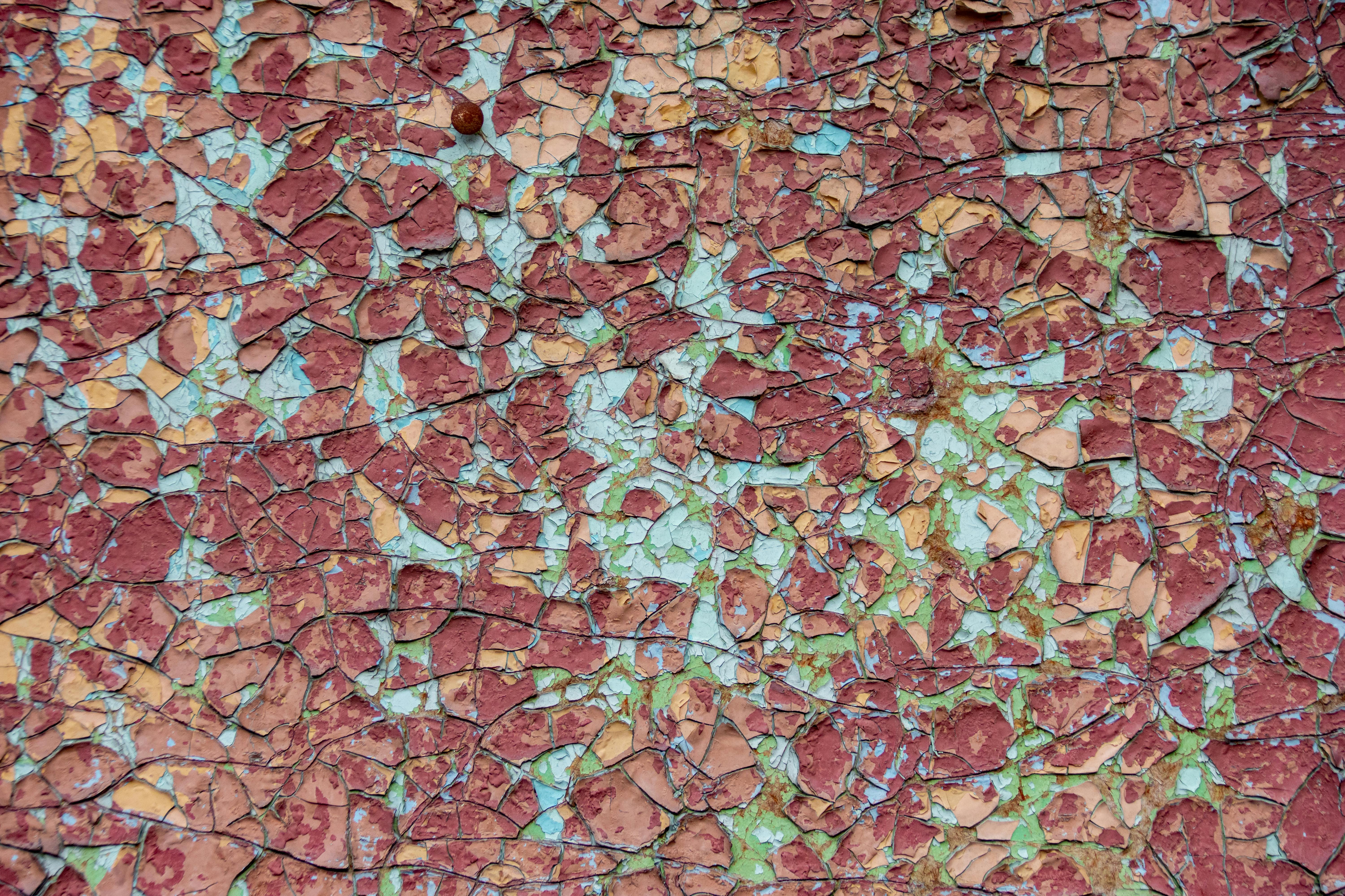 Kostnadsfria Närbild av en sprucken, flerfärgad texturerad yta, perfekt för bakgrunder eller mönster. Stock foto