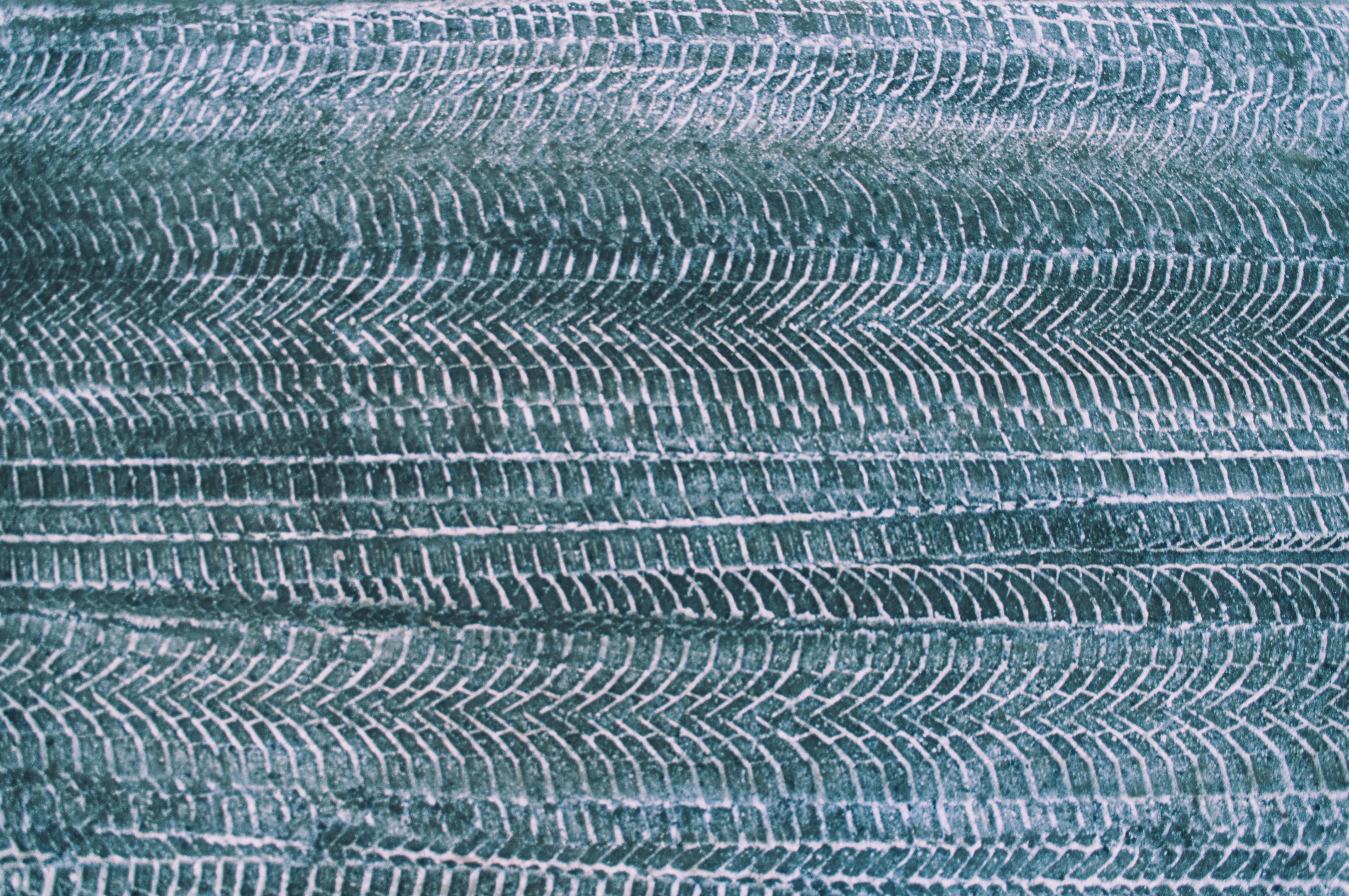 bezplatná Detailní záběr stop pneumatik na zasněženém a zledovatělém povrchu, zobrazující složité vzory a texturu. Základová fotografie