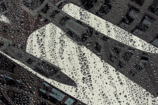 Close-up of raindrops on a car window reflecting a cityscape. Artistic and detailed.