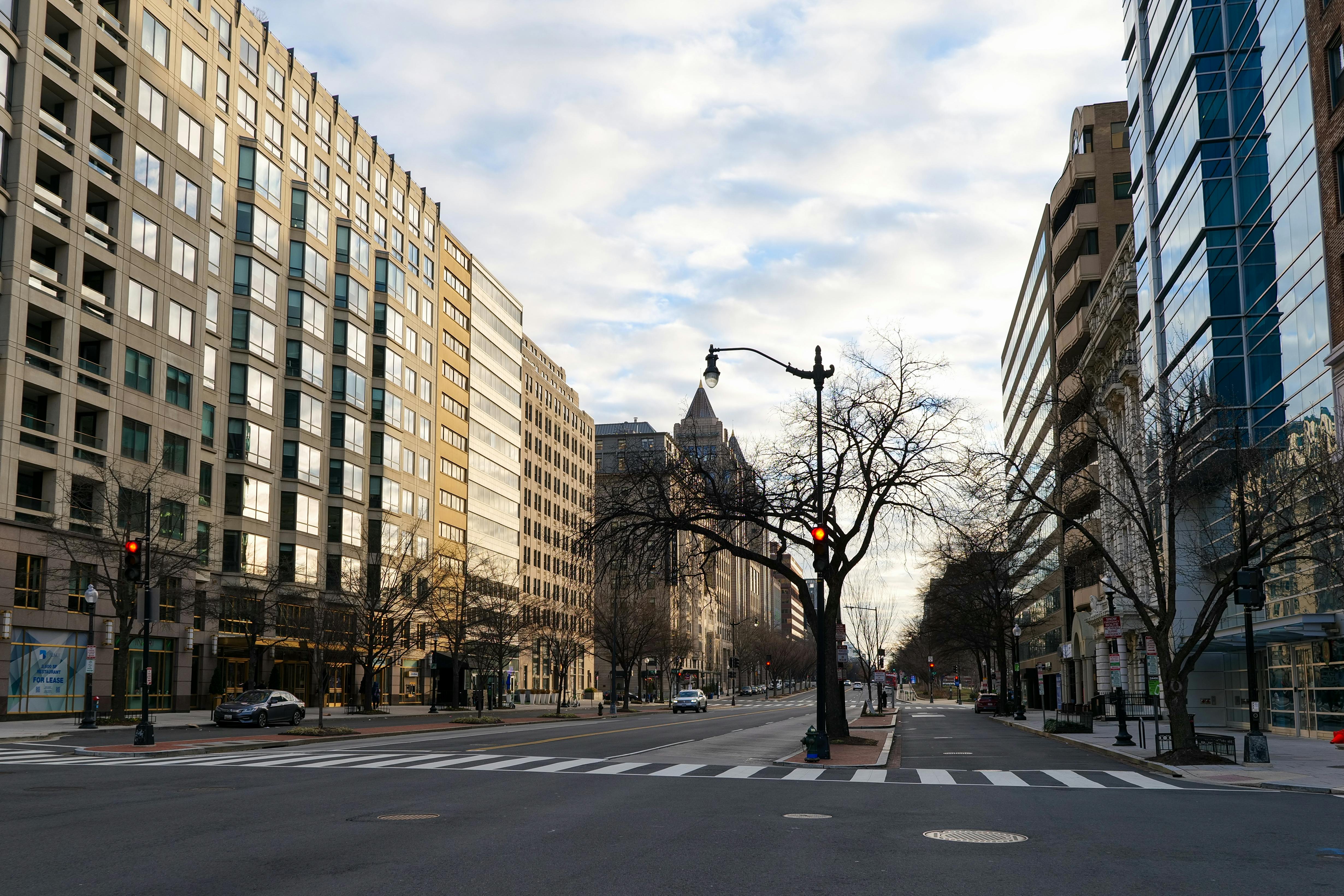 A deserted street in Washington DC showcasing modern urban architecture under a cloudy sky.