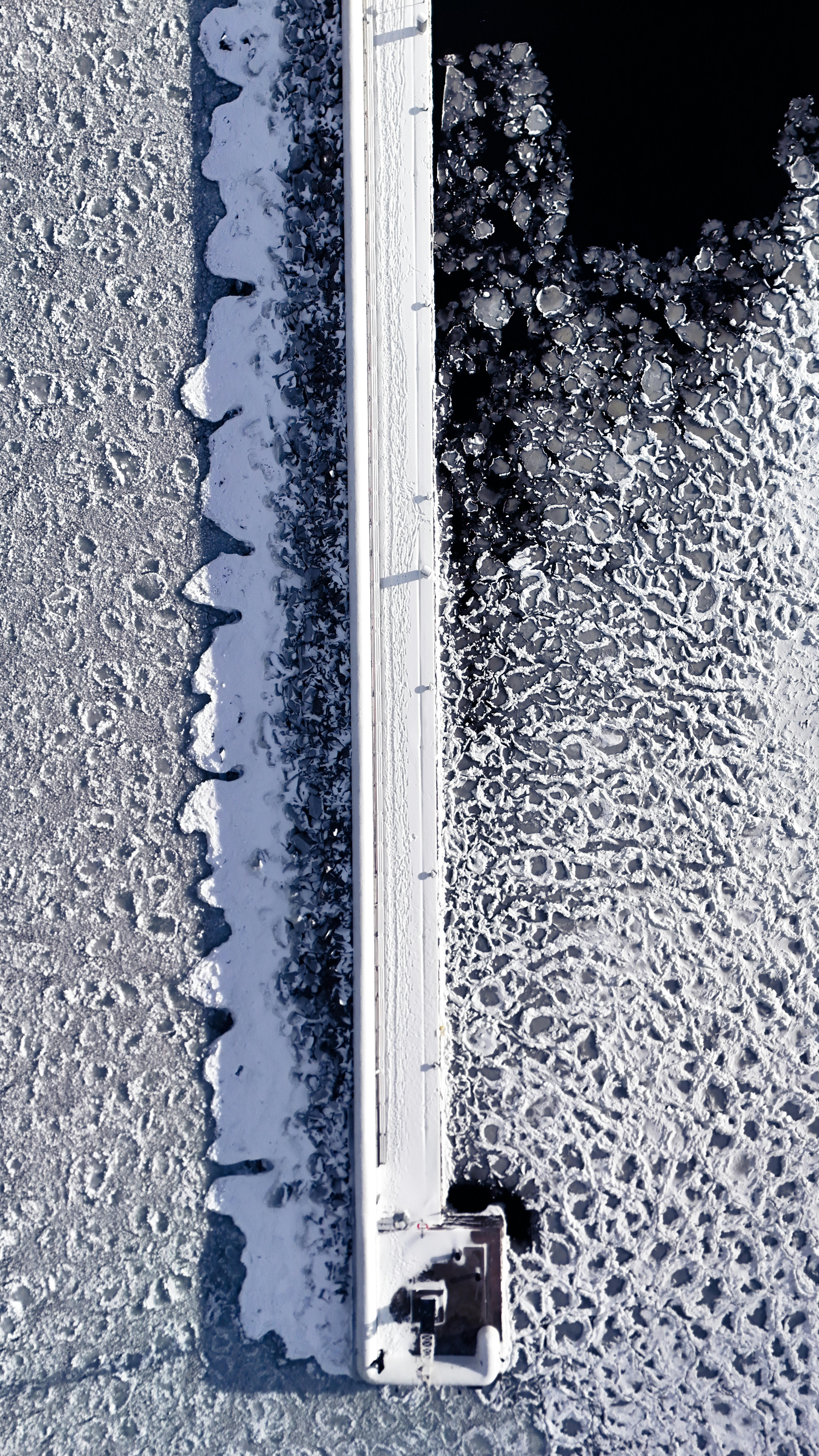 gratis Luchtfoto van een bevroren pier en ijskoud water in Jönköping, Zweden, in de winter. Stockfoto