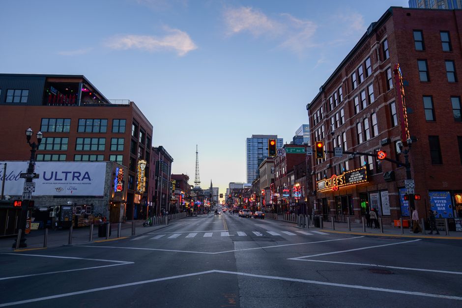 Bustling Broadway Street in Nashville at dusk, showcasing lively nightlife and iconic landmarks.