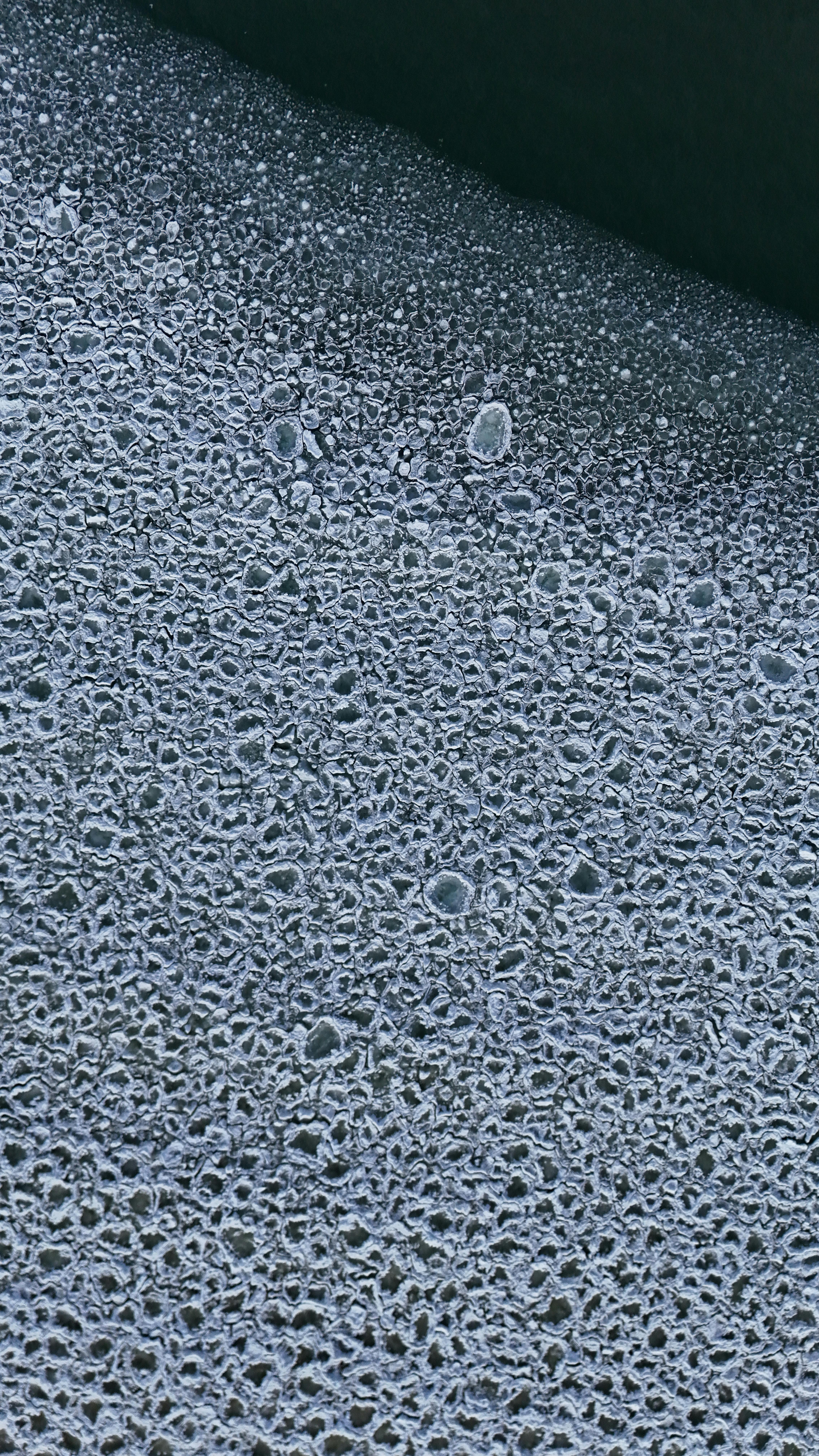 gratis Een gedetailleerde abstracte textuur van ijs op het oppervlak van een bevroren meer in Jönköping, Zweden. Stockfoto