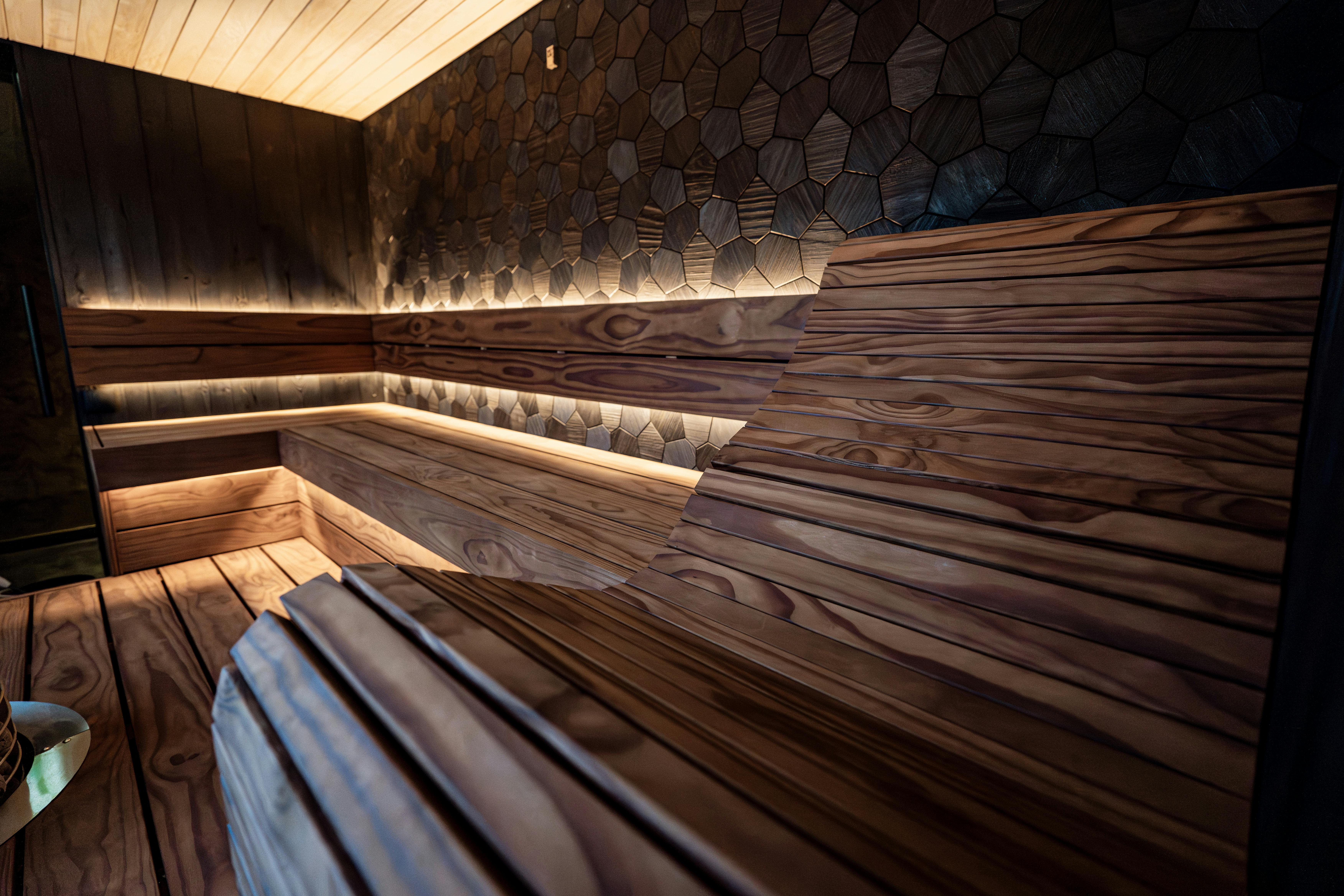 Détendez-vous dans ce sauna moderne et élégant, doté de chaleureux panneaux de bois et d'un éclairage LED d'ambiance.