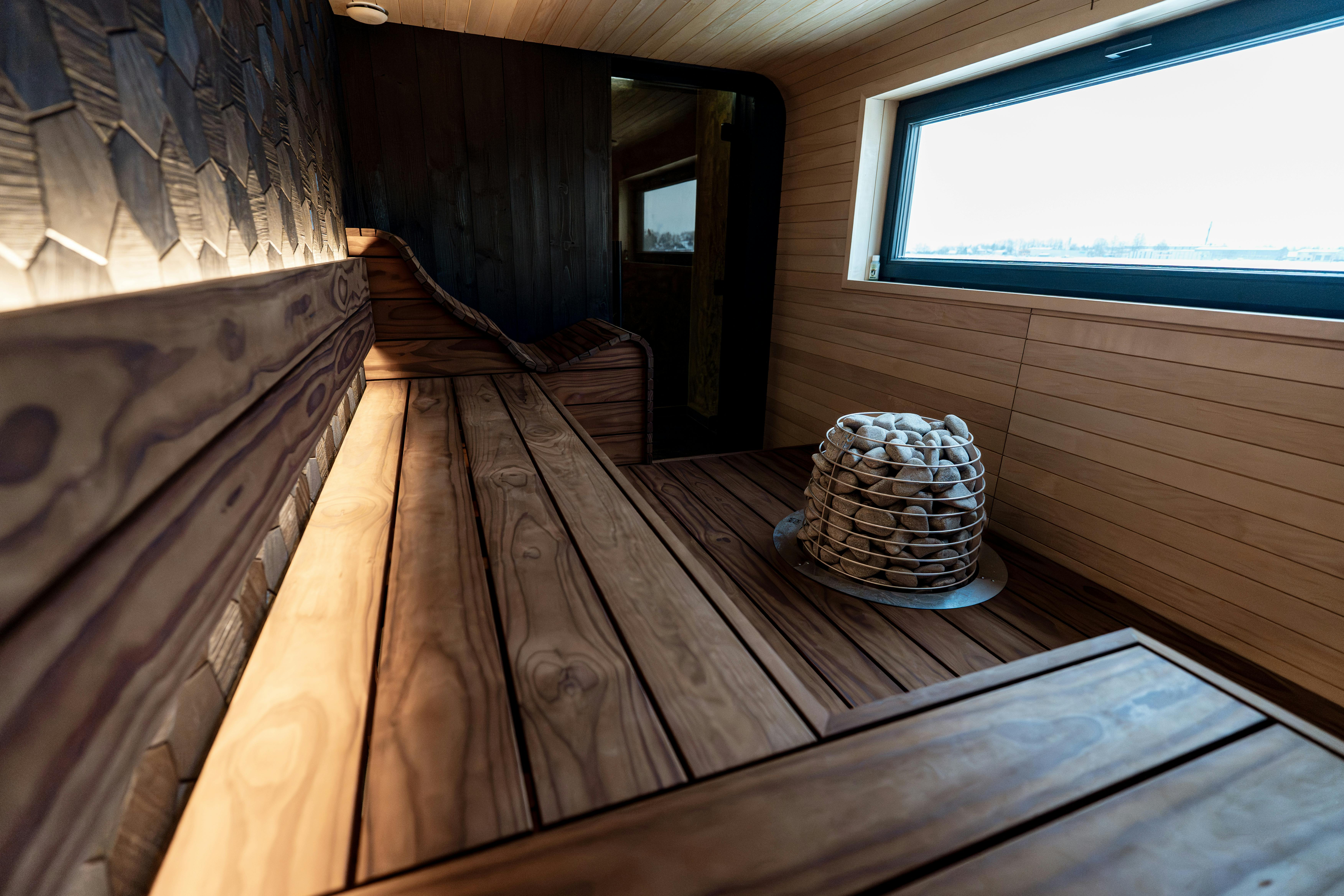 Découvrez l'élégance d'un sauna de style nordique avec ses panneaux de bois modernes et son poêle unique.