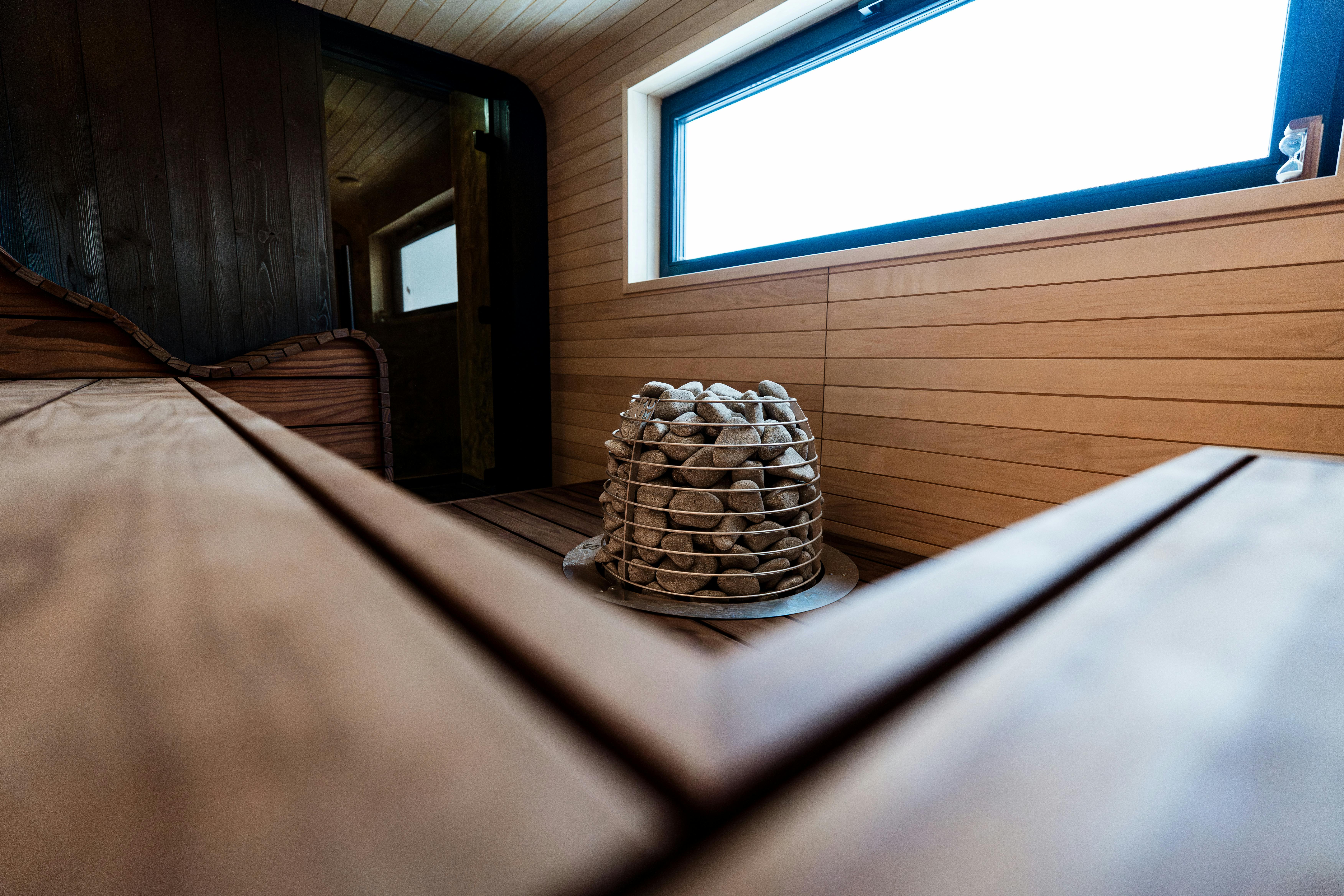 Ücretsiz Şık ahşap tasarımı ve üst düzey rahatlama için elektrikli ısıtıcıya sahip modern bir sauna iç mekanını keşfedin. Stok Fotoğraflar