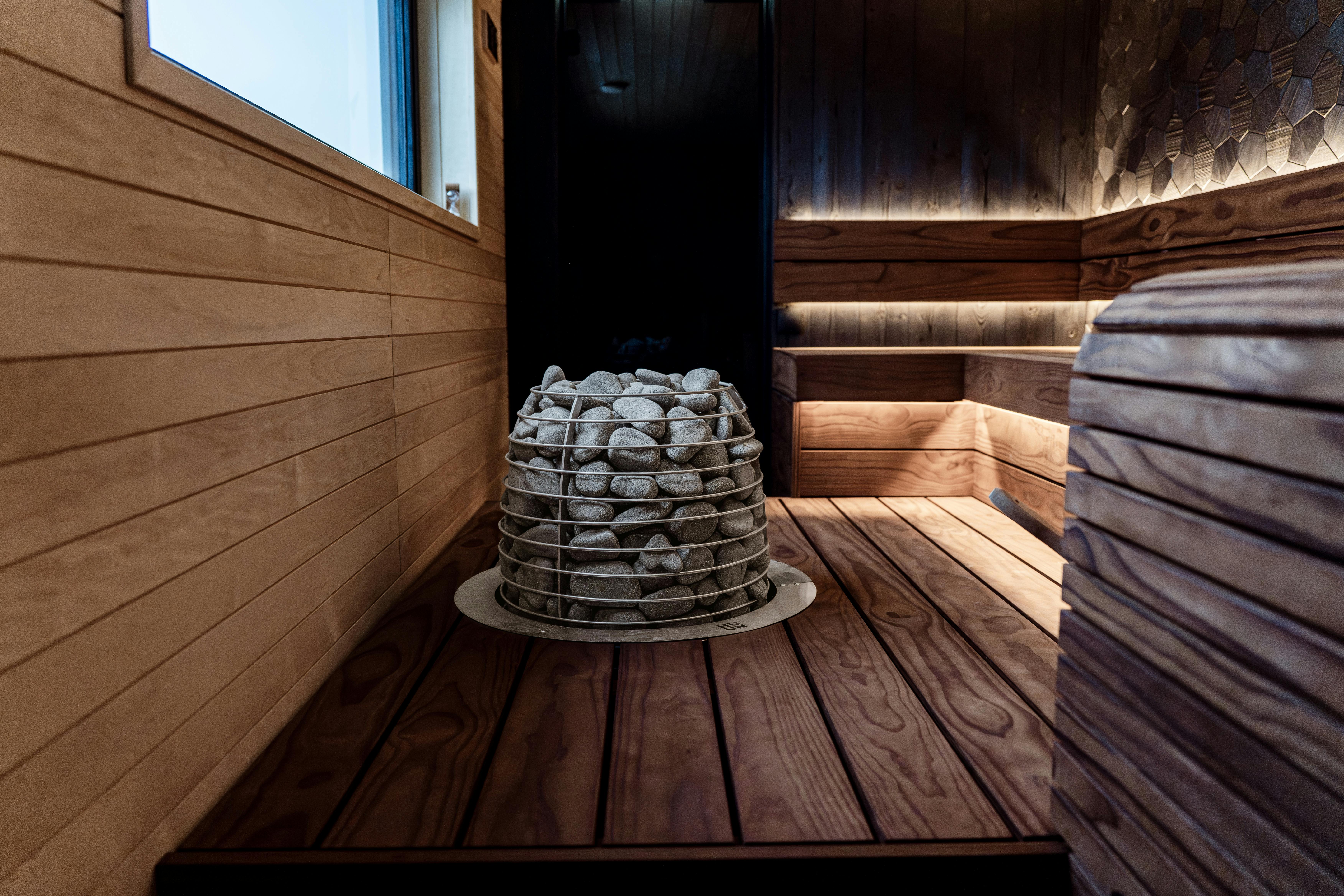 Gratis Moderna sauna interna con pannelli in legno e stufa elettrica in pietra, ideale per il relax. Foto a disposizione