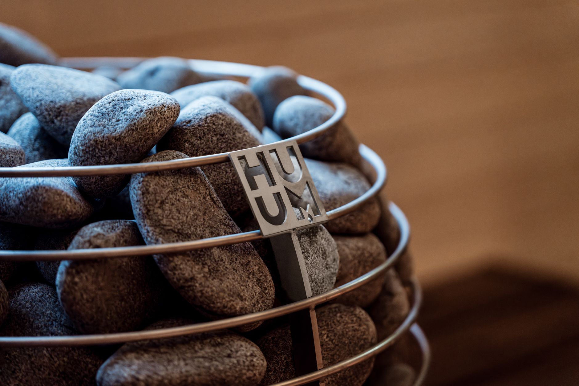 Close-up of a modern sauna heater filled with stones, showcasing Nordic design elements.