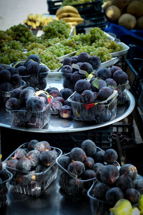 Free Vibrant display of fresh figs and grapes at an outdoor market in Diyarbakır, Türkiye. Stock Photo