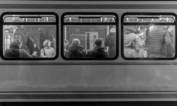 Monochrome view of passengers inside a city train, showcasing urban travel lifestyle.